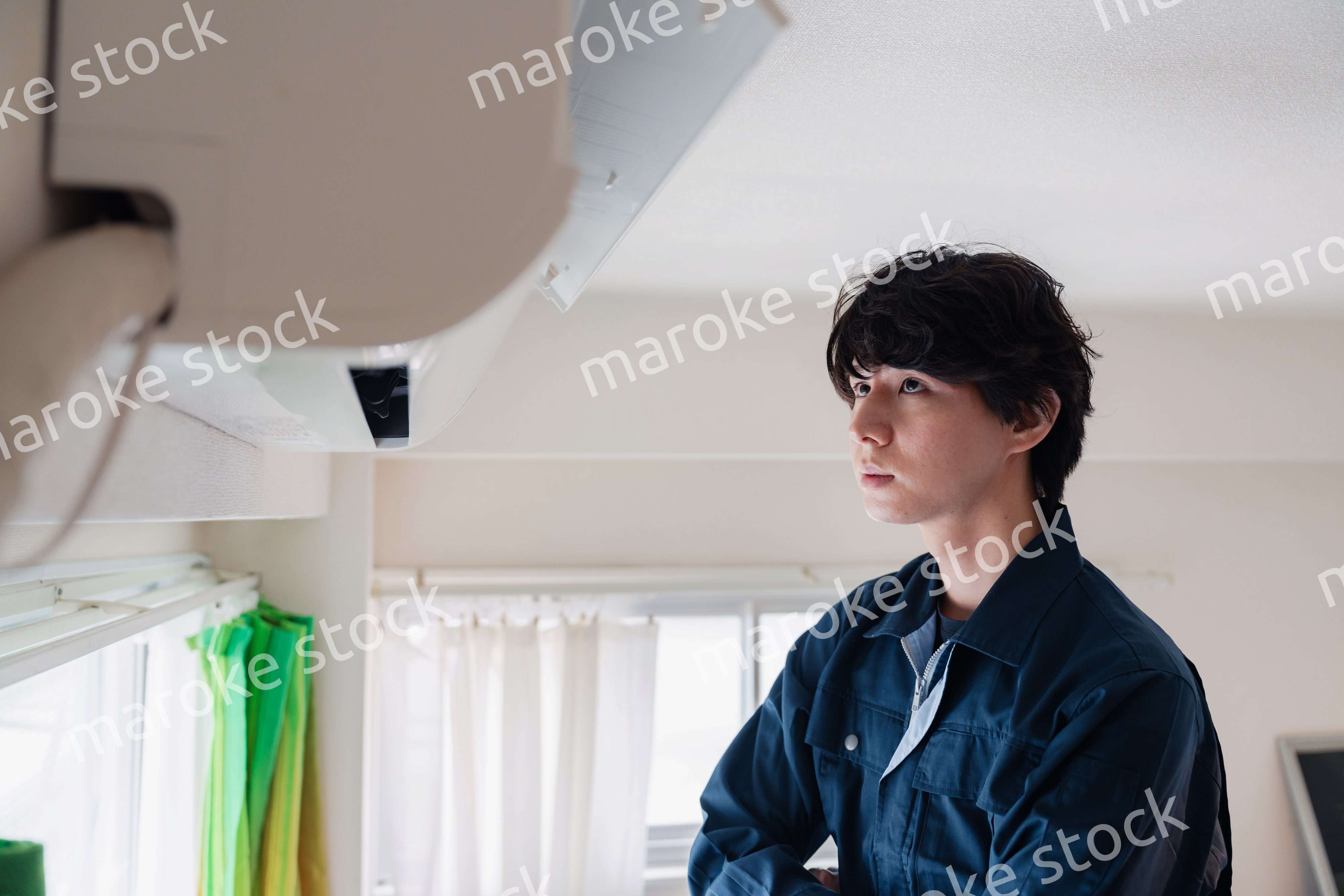 エアコンの点検をする男性
