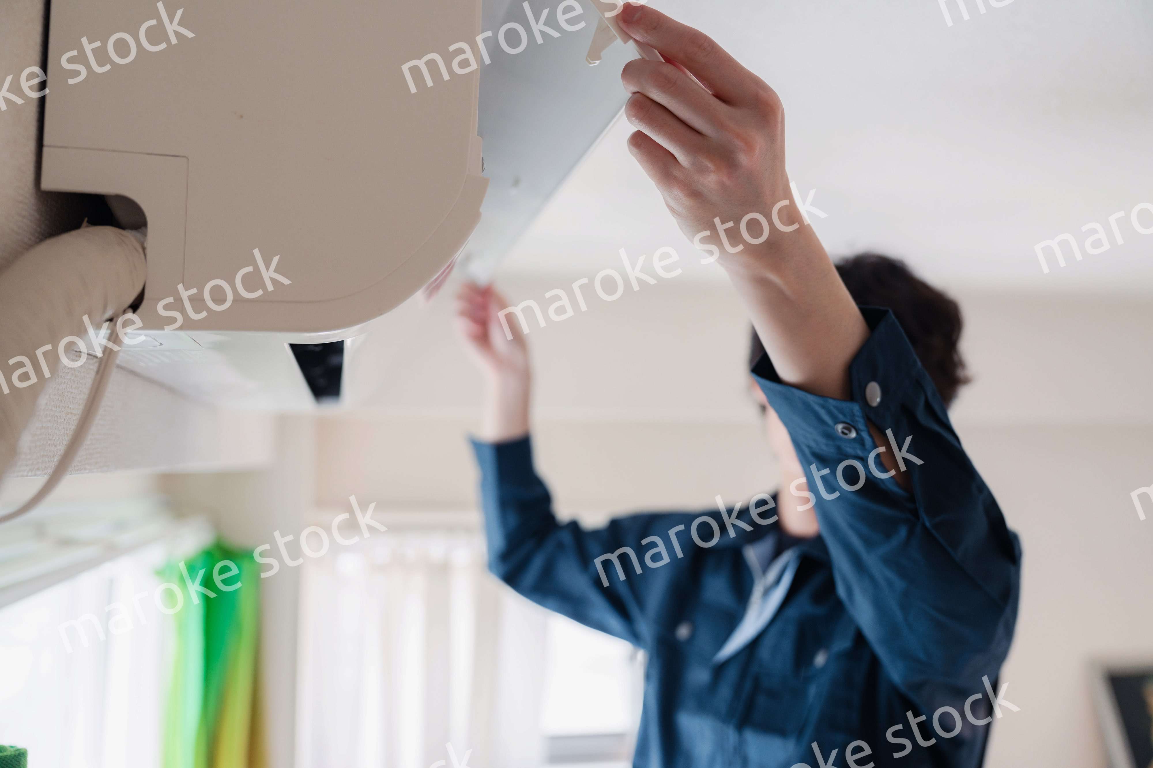 エアコンの点検をする男性