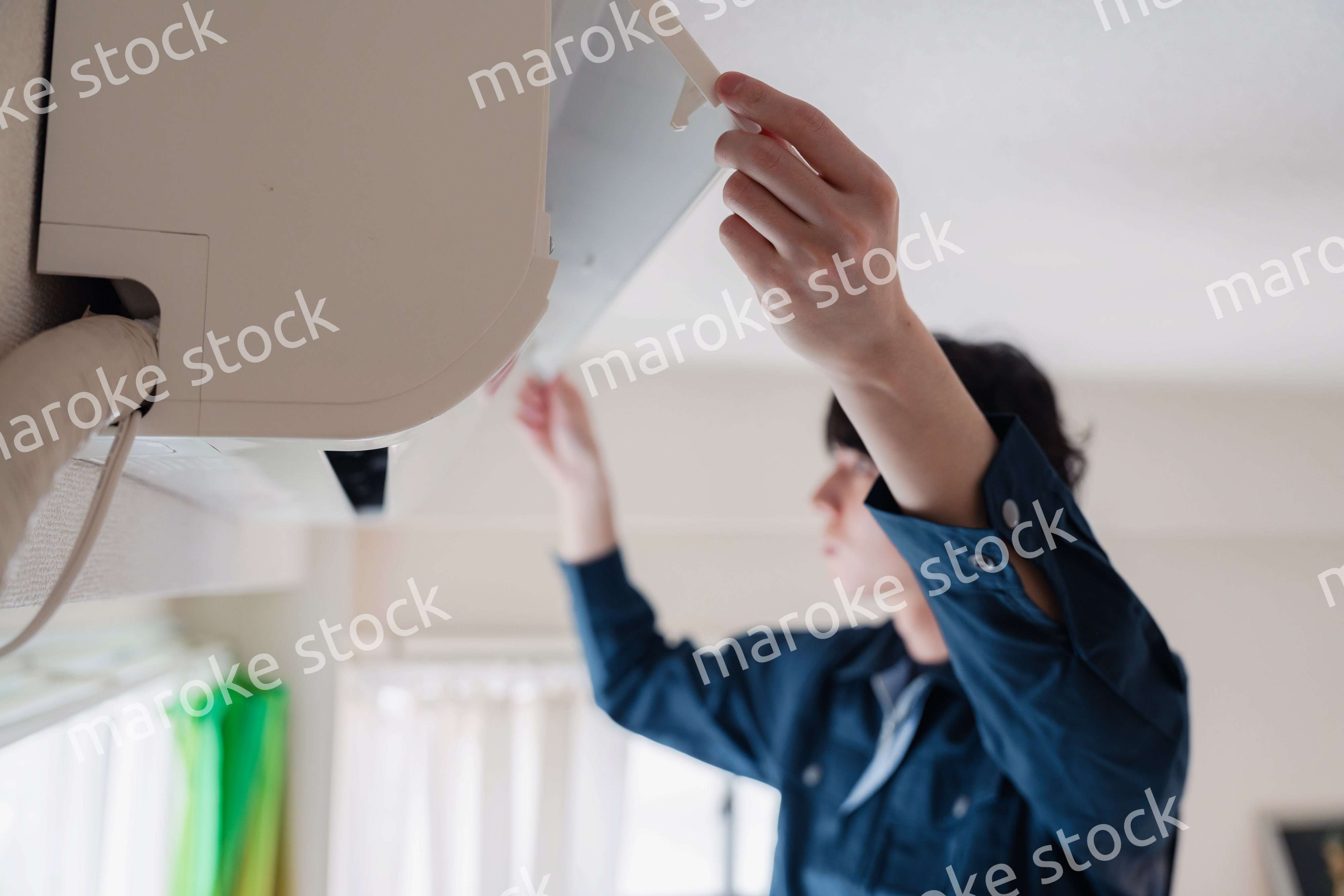 エアコンの点検をする男性