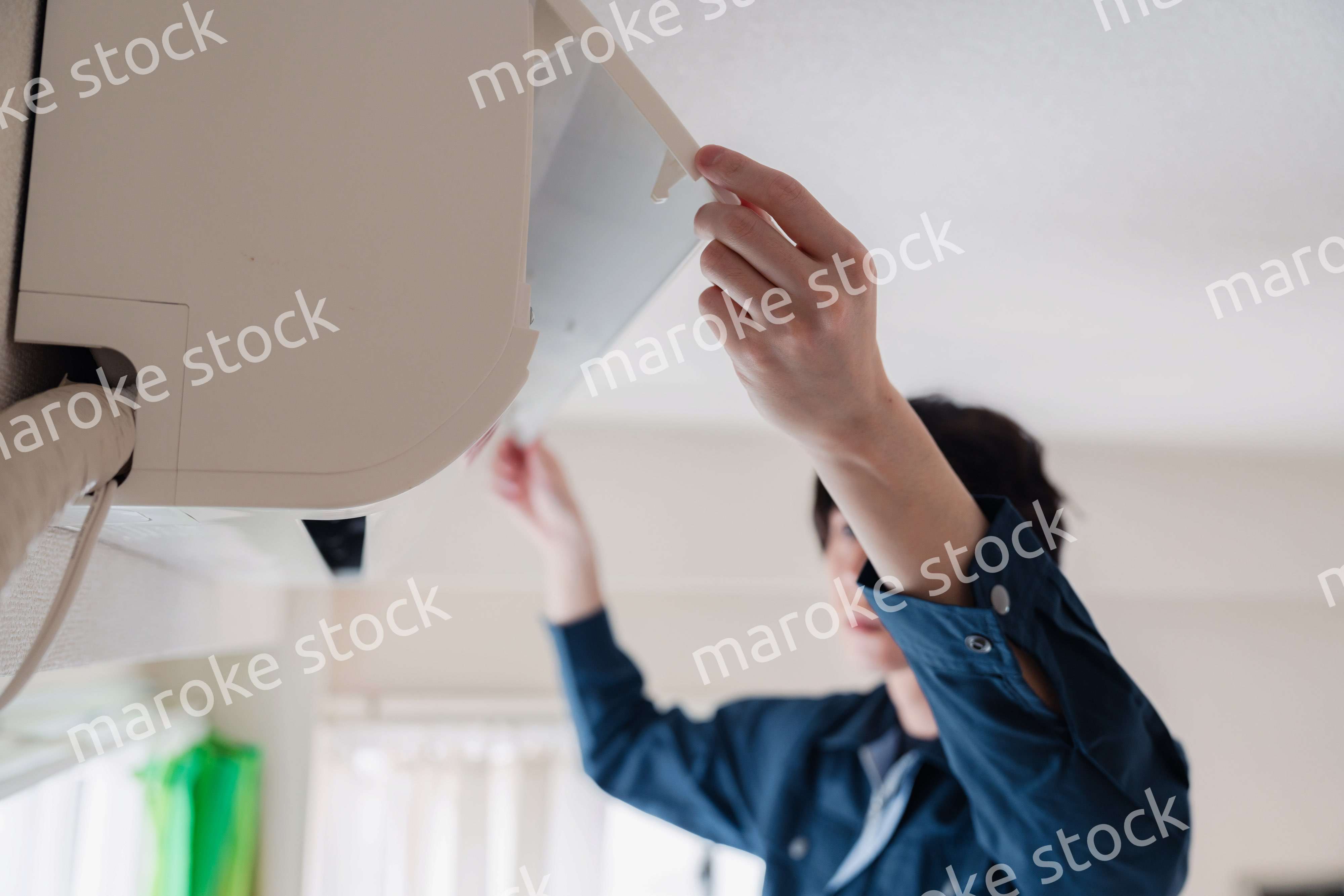 エアコンの点検をする男性