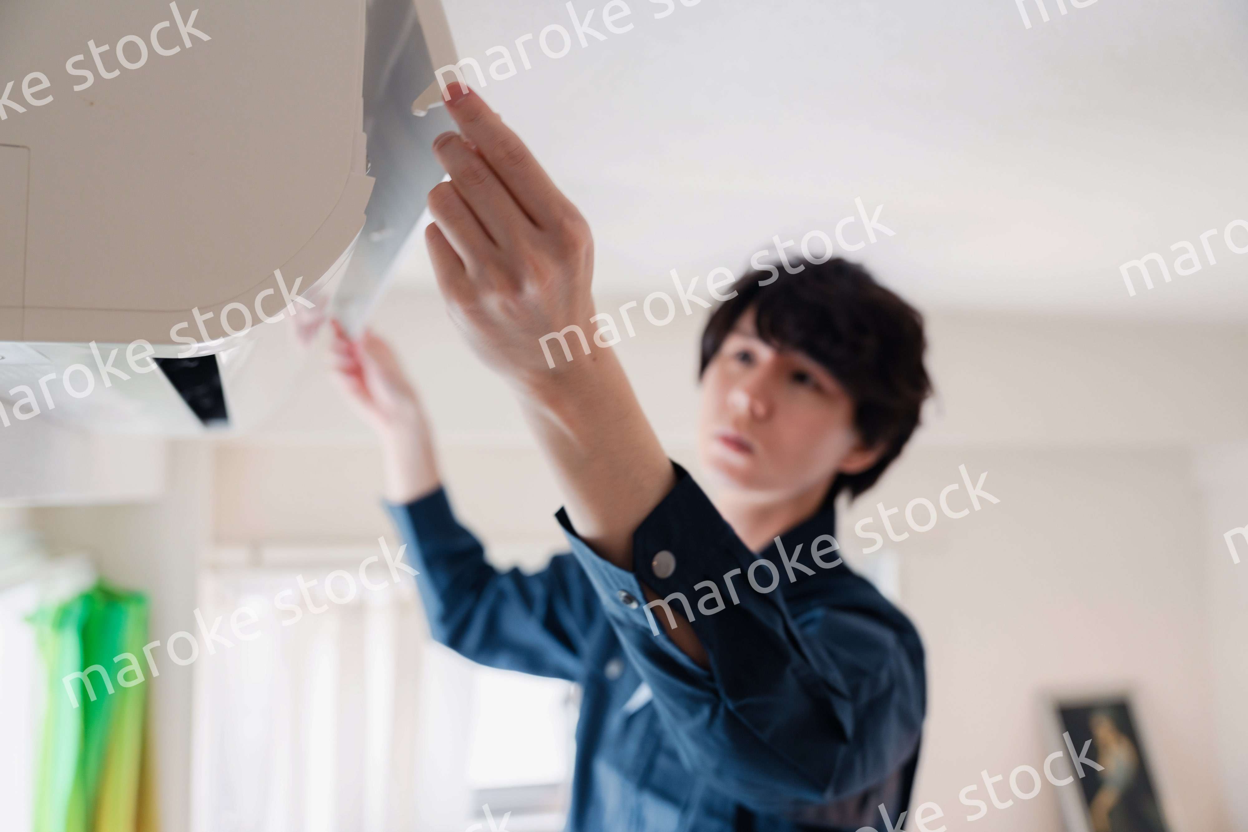 エアコンの点検をする男性