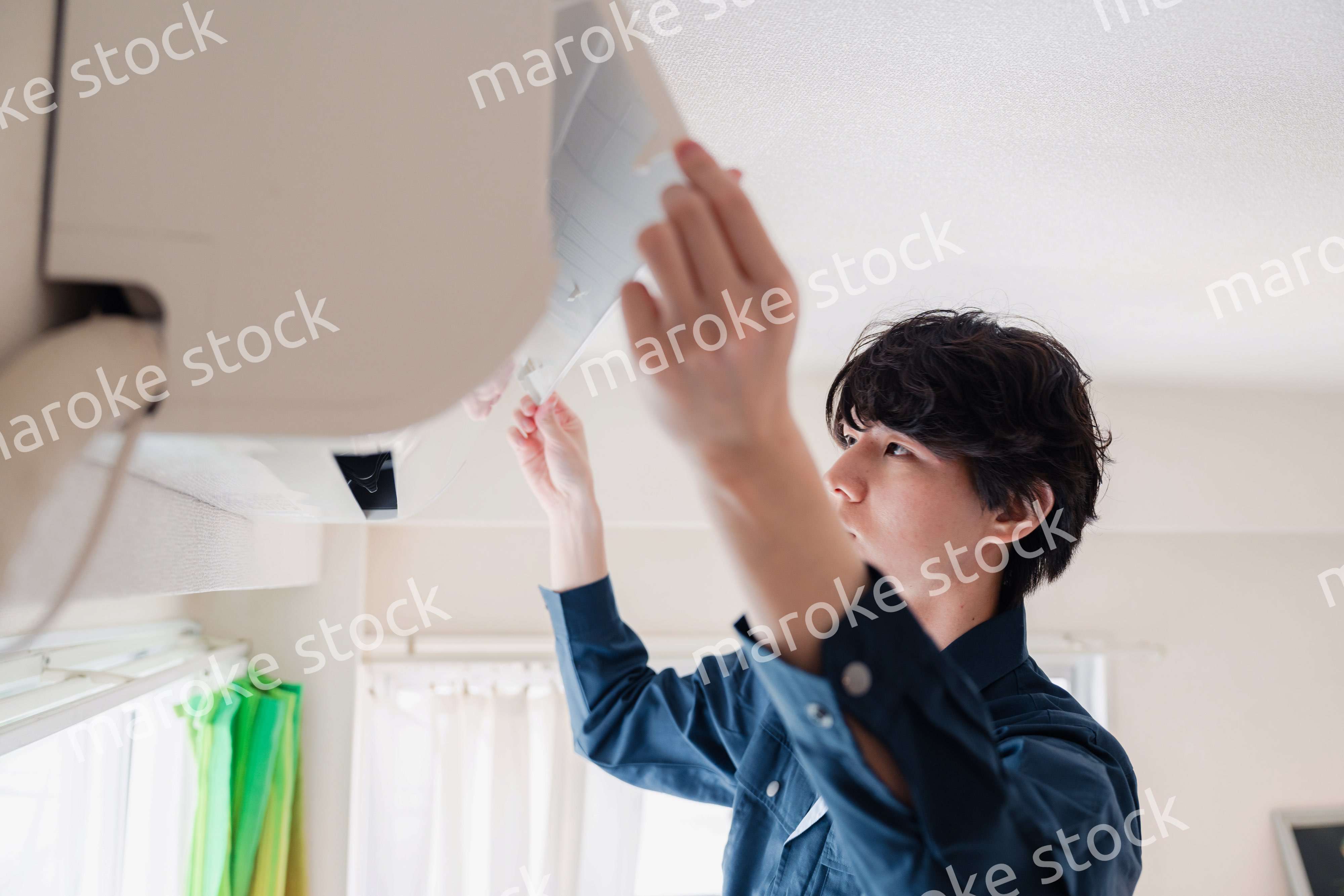 エアコンの点検をする男性