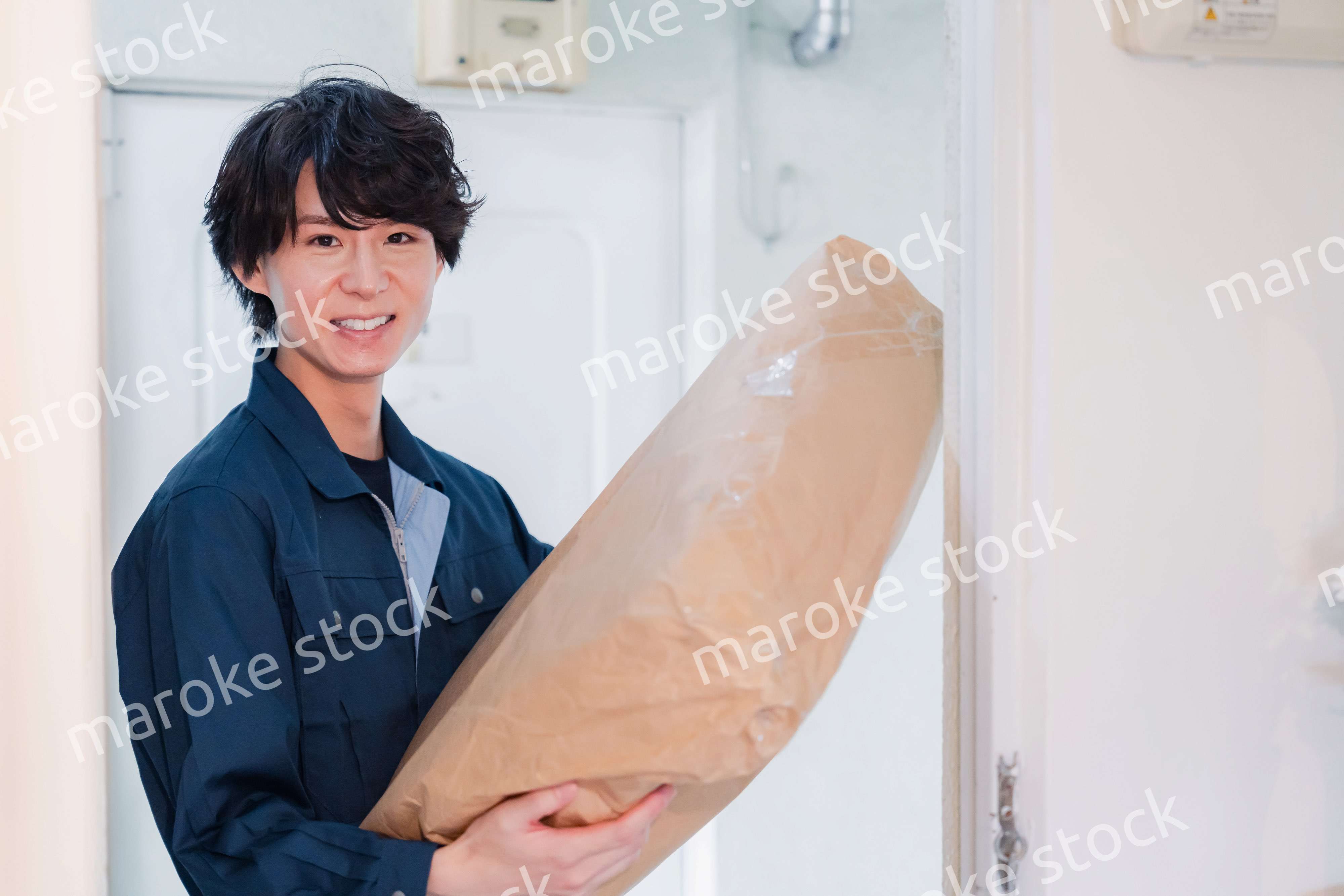 古いマンションに荷物を届ける男性