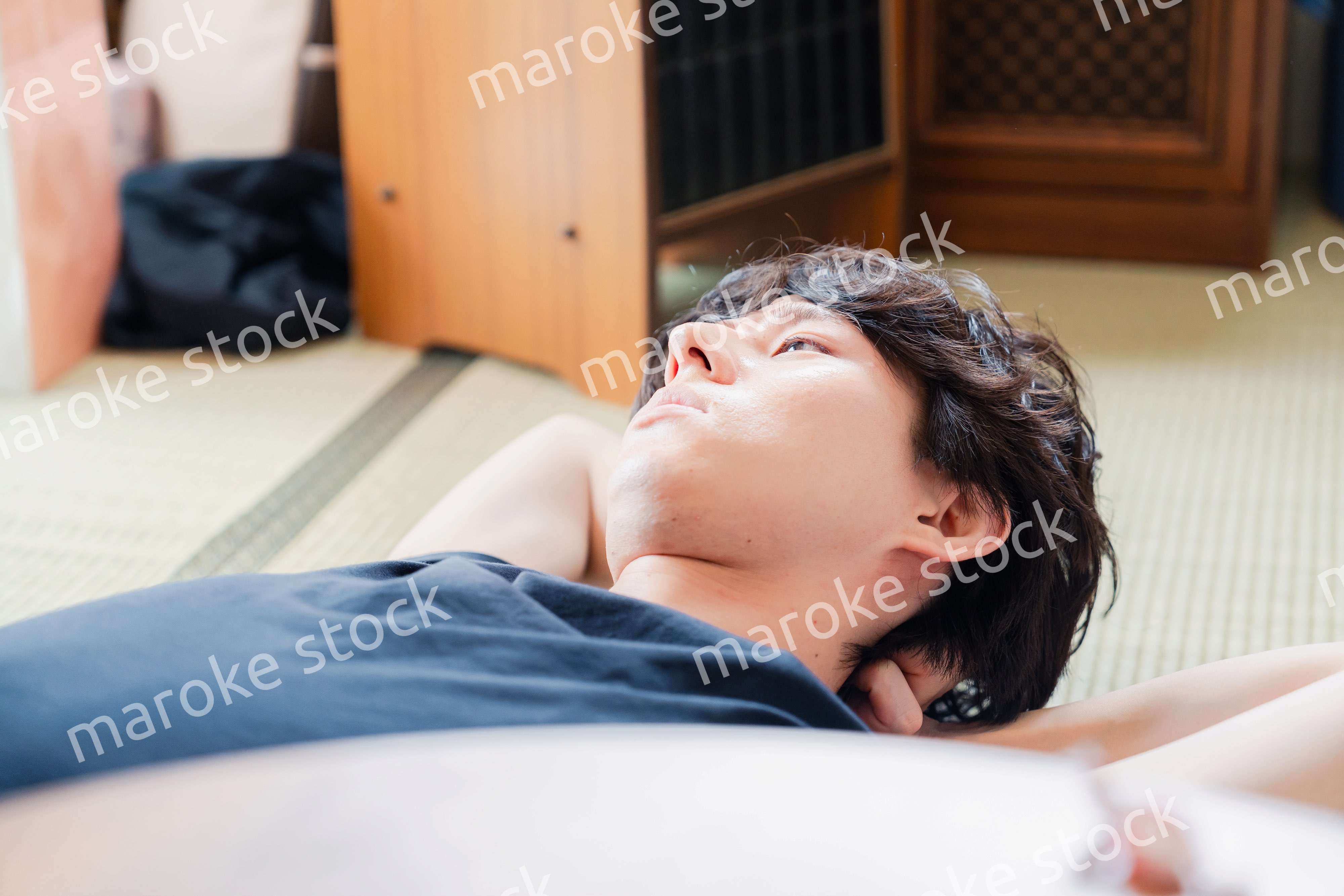 実家で寝転がる若い男性