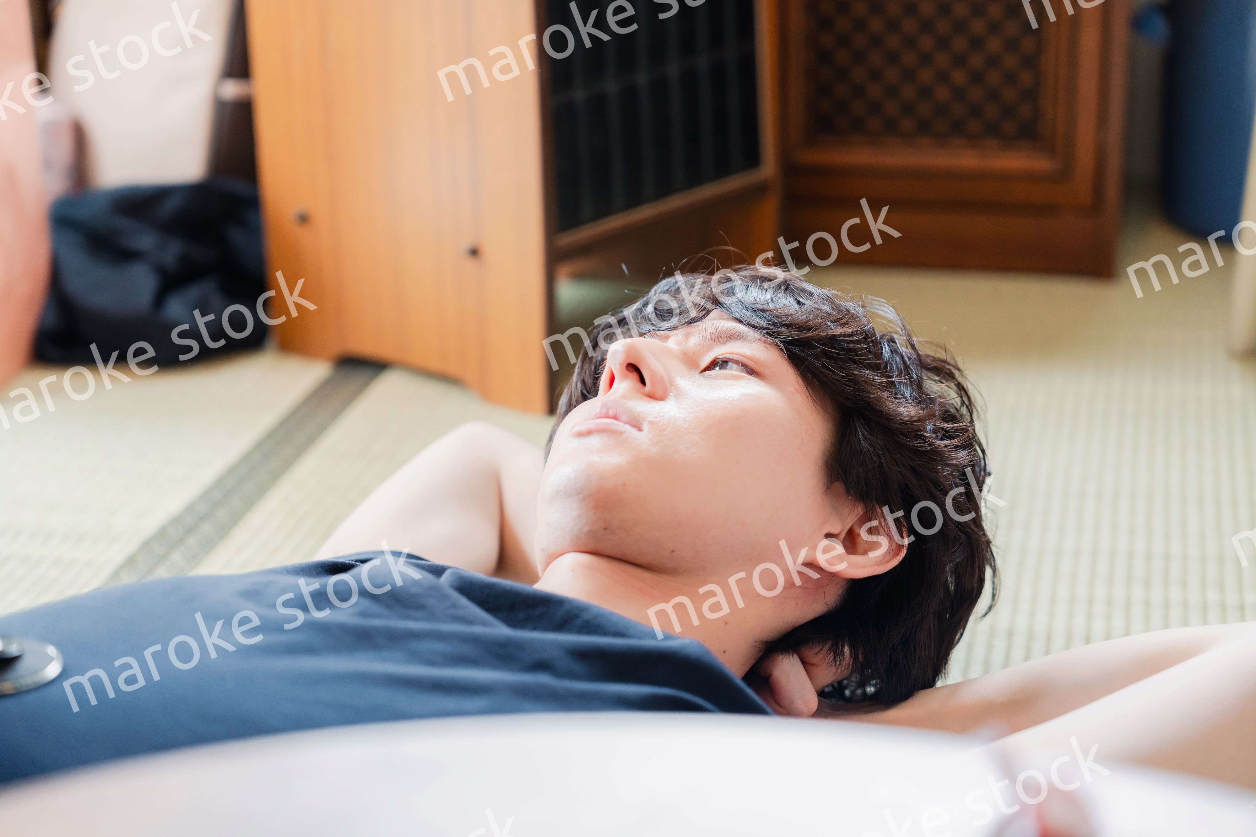 実家で寝転がる若い男性