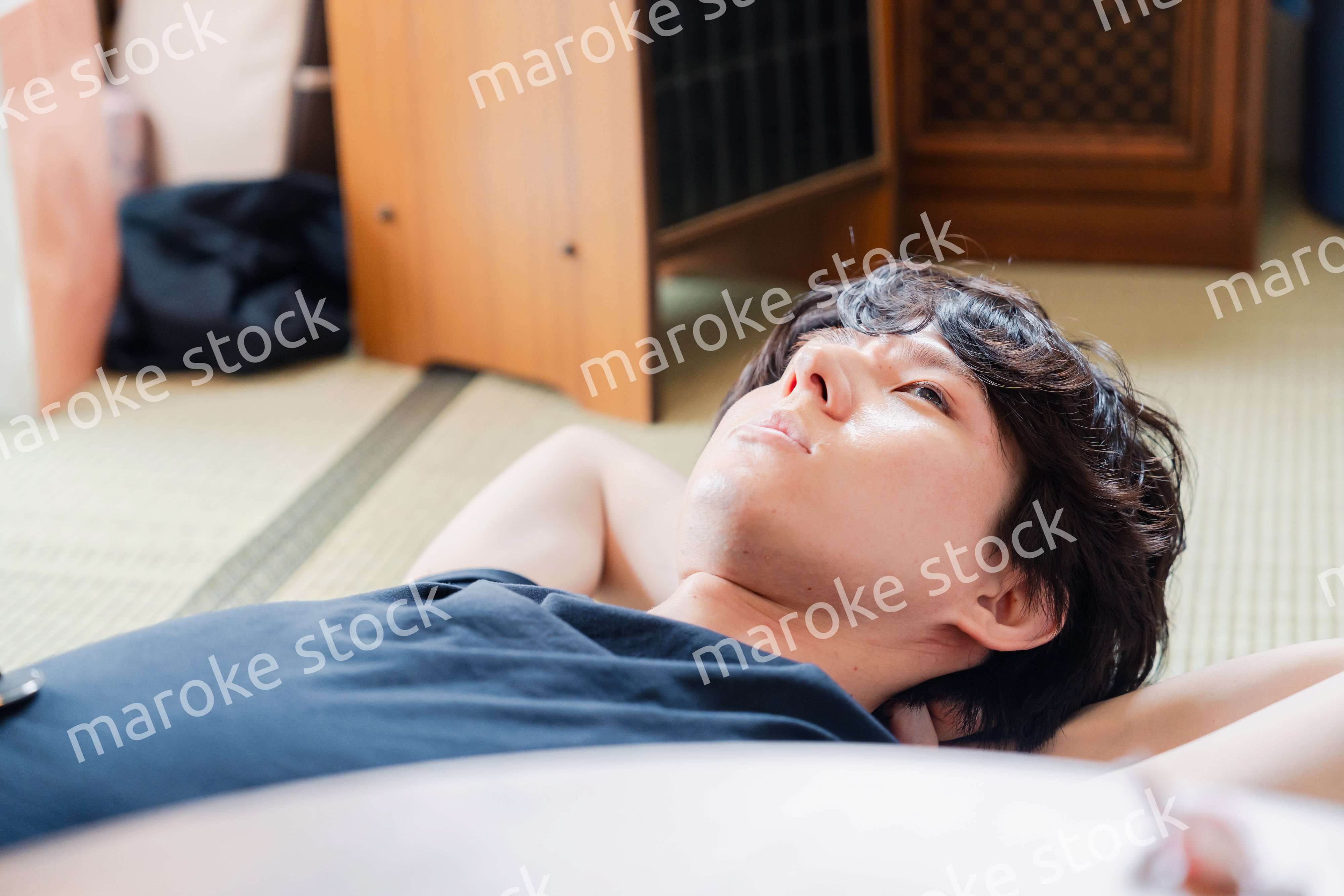 実家で寝転がる若い男性