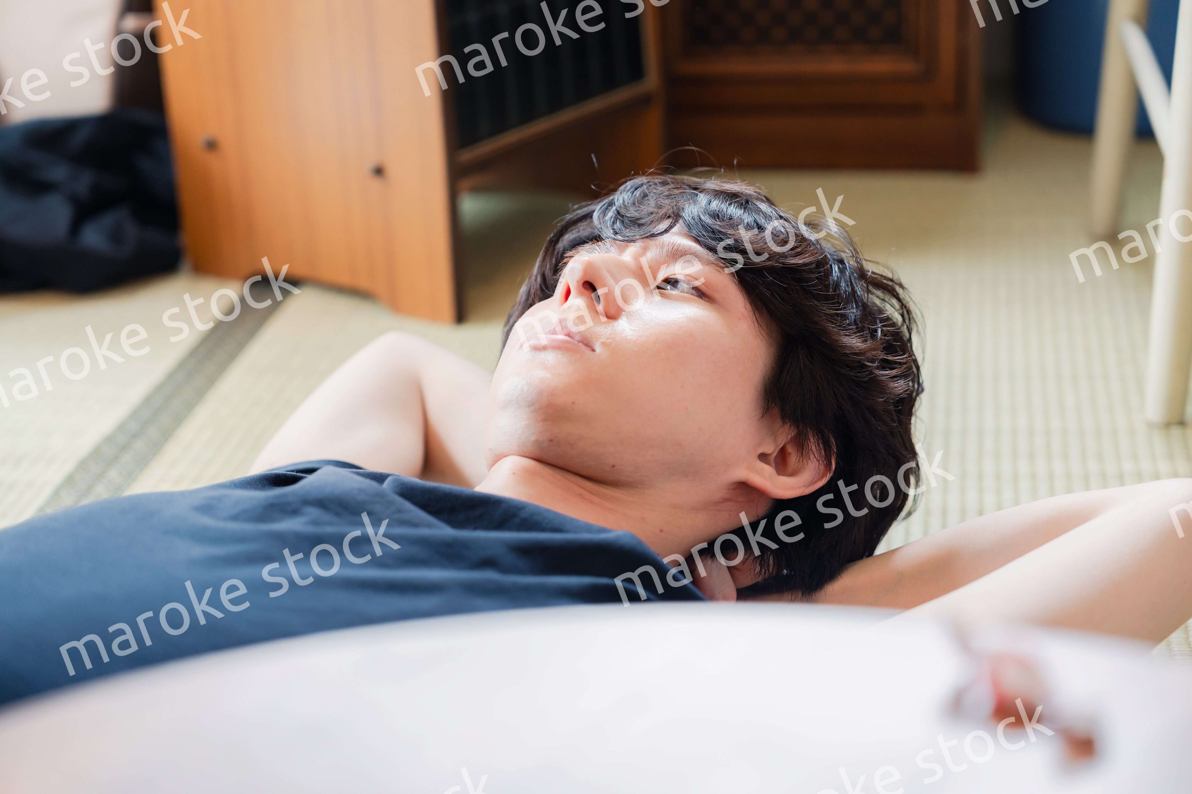 実家で寝転がる若い男性