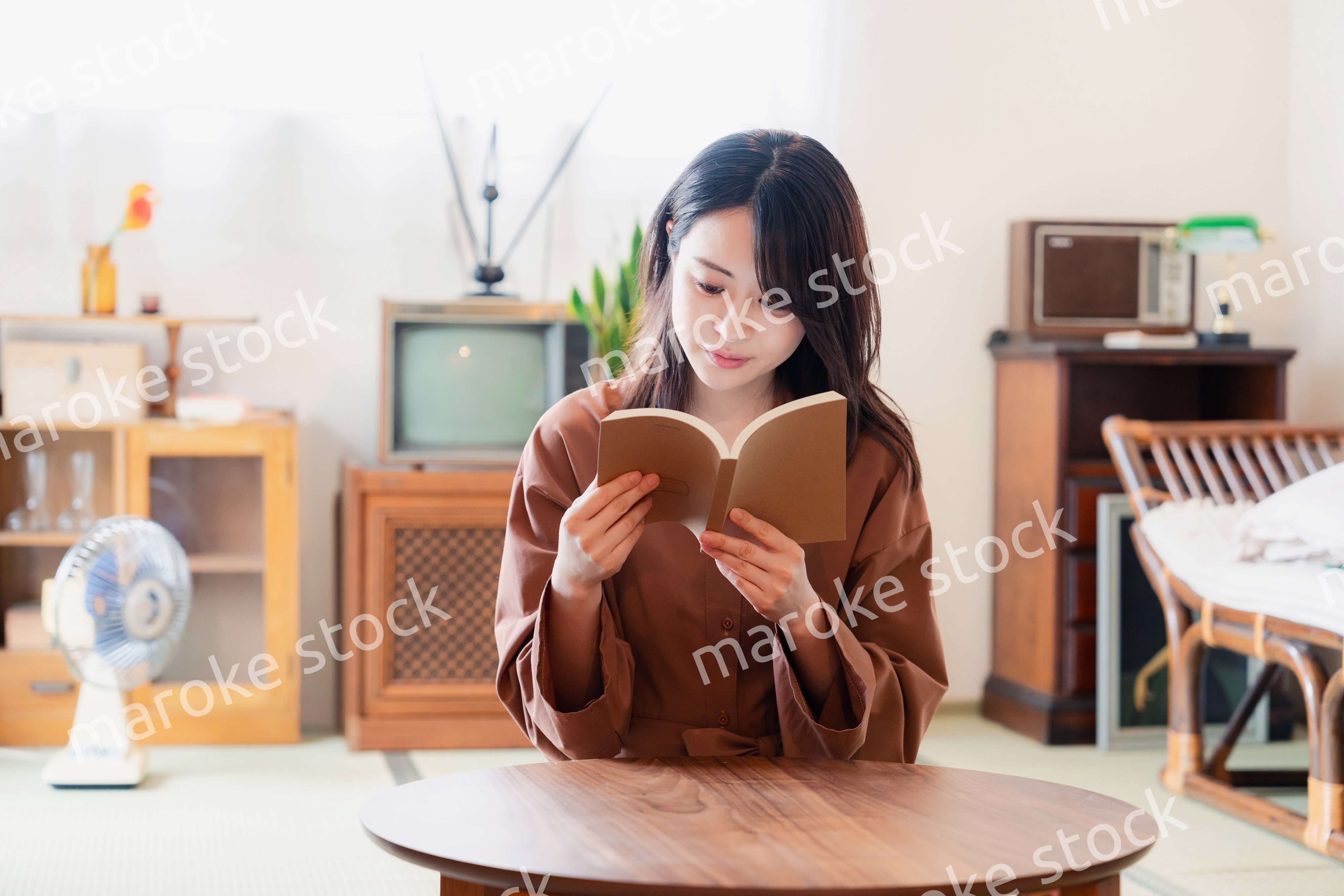 古風な雰囲気の家で読書をする若い女性