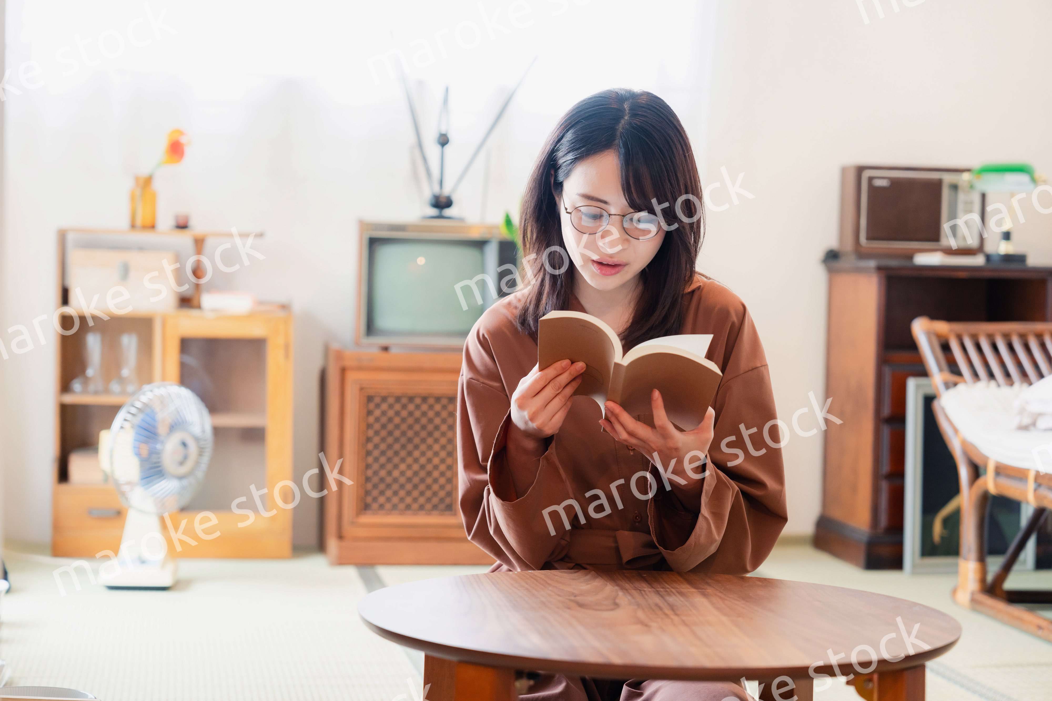 古風な雰囲気の家で読書をする若い女性