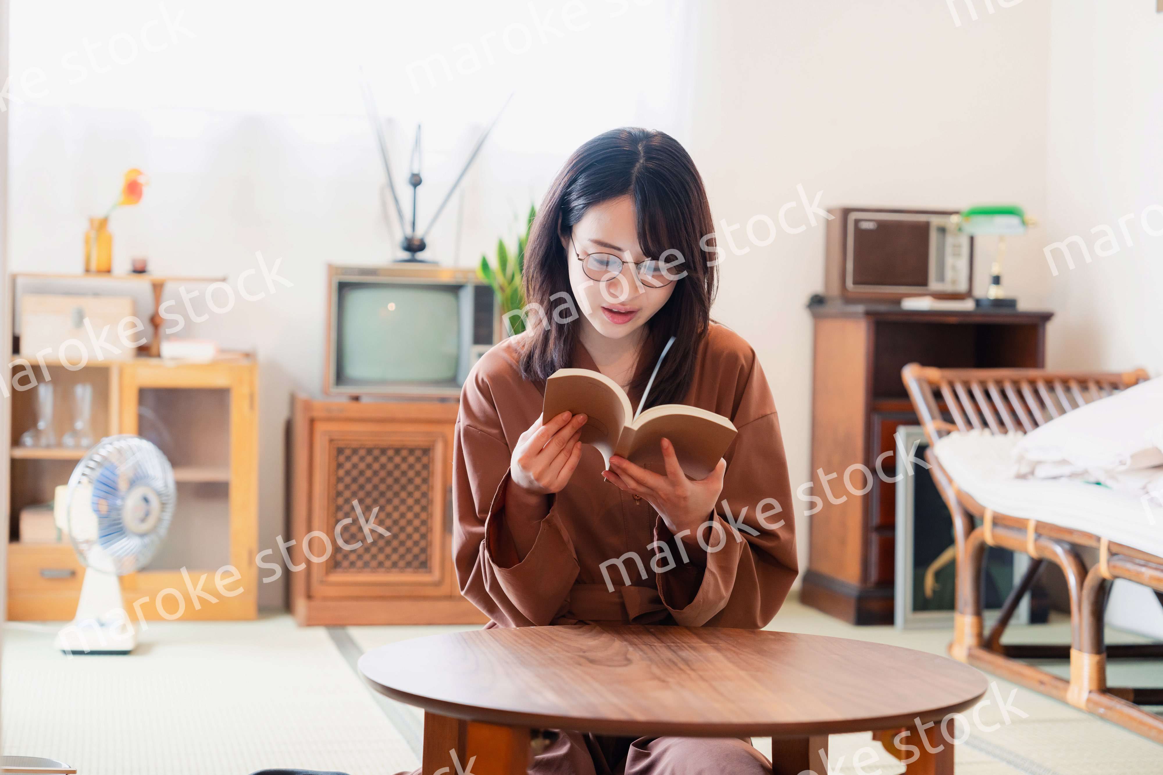 古風な雰囲気の家で読書をする若い女性