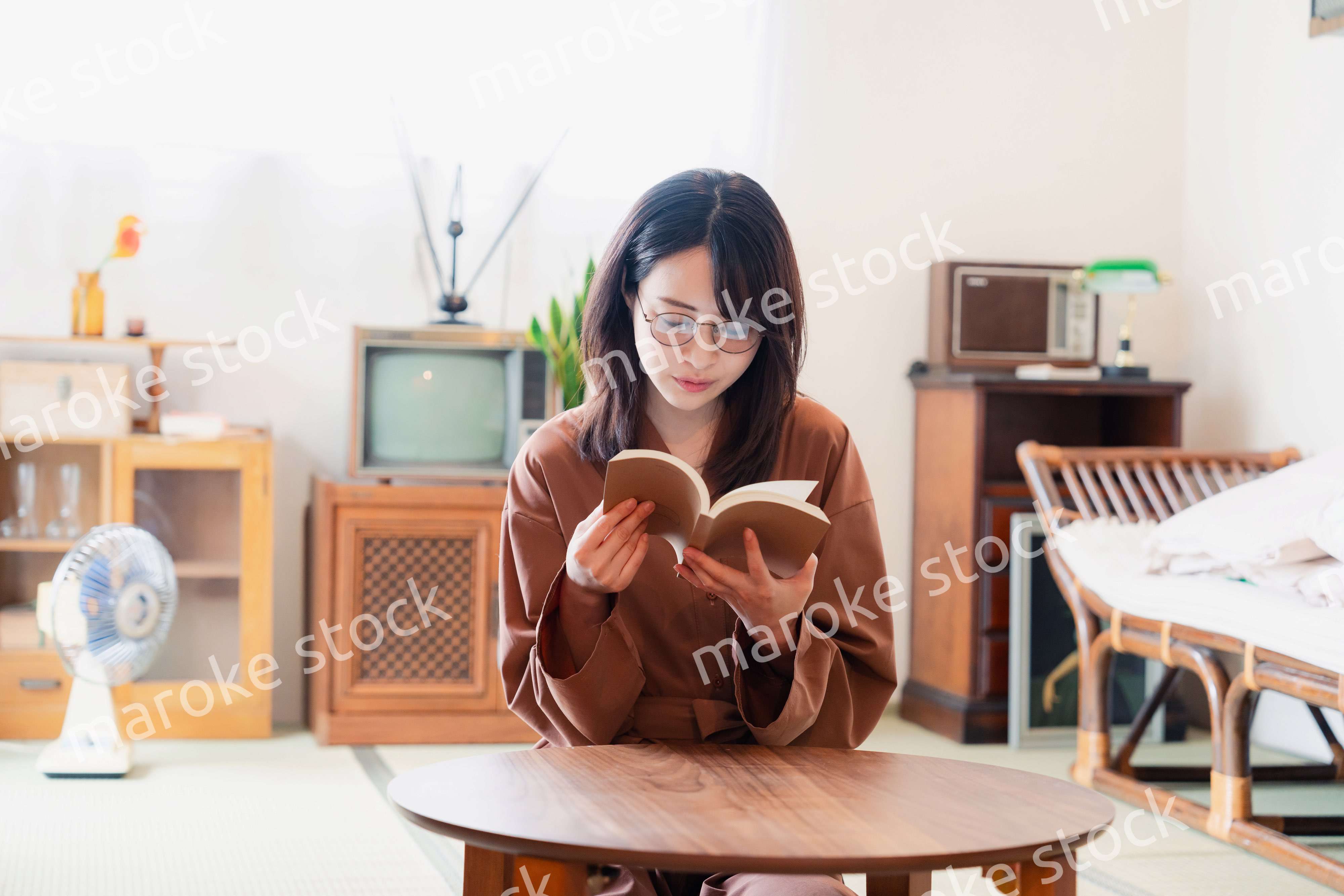 古風な雰囲気の家で読書をする若い女性