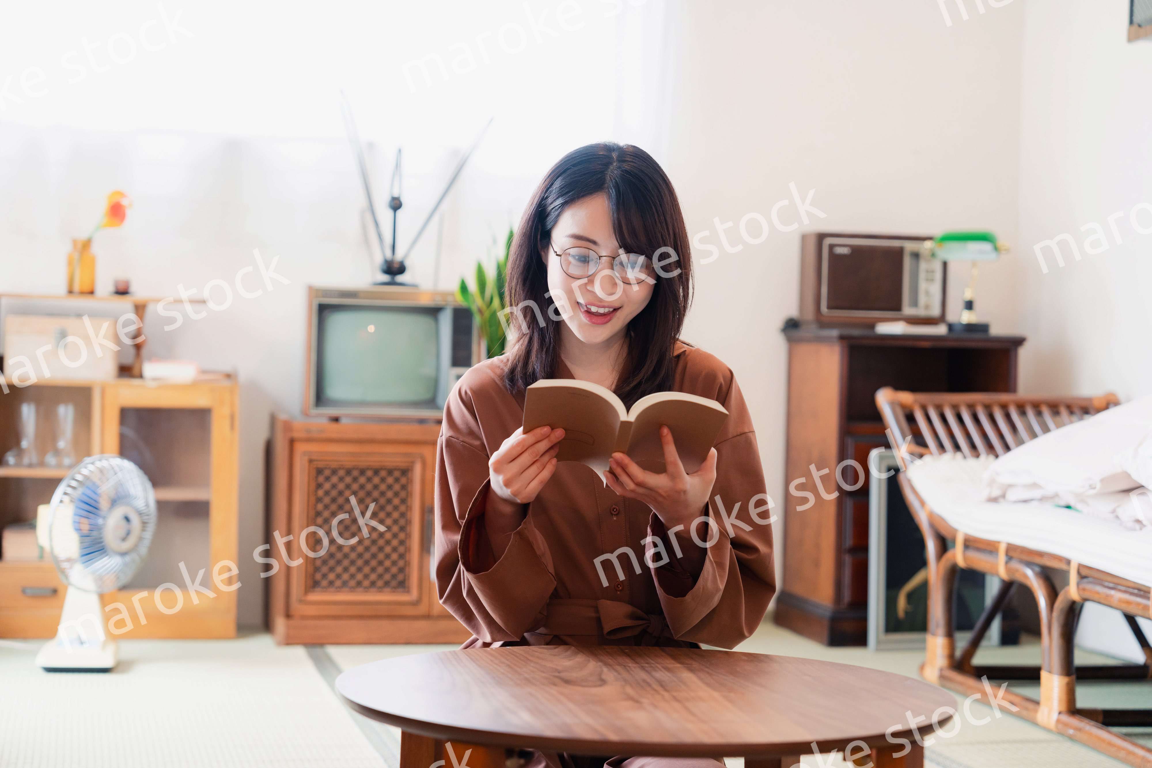 古風な雰囲気の家で読書をする若い女性