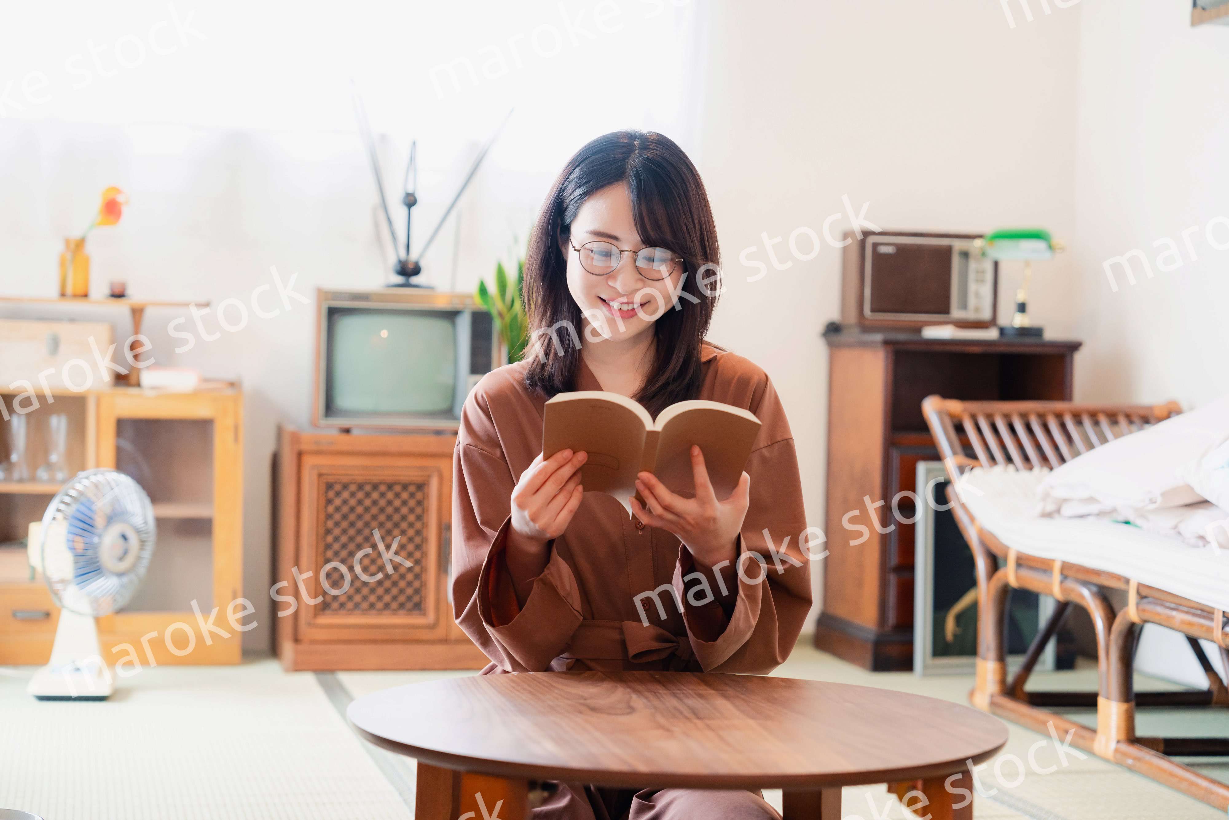 古風な雰囲気の家で読書をする若い女性