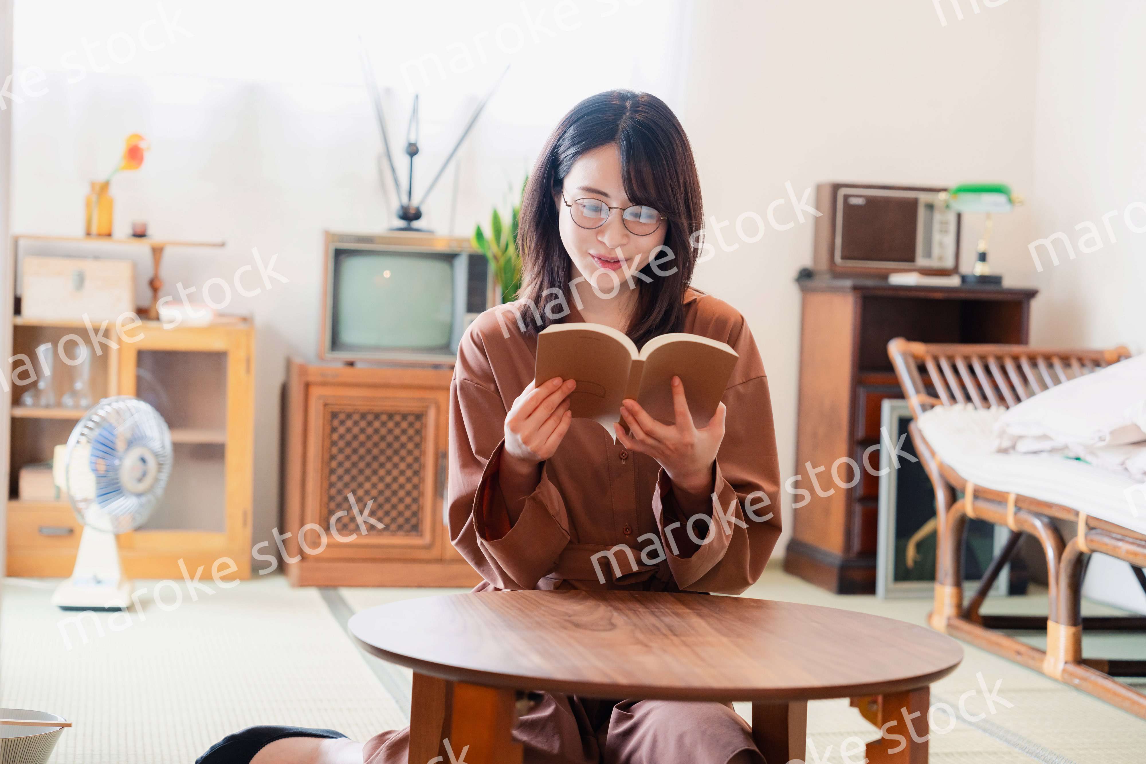 古風な雰囲気の家で読書をする若い女性