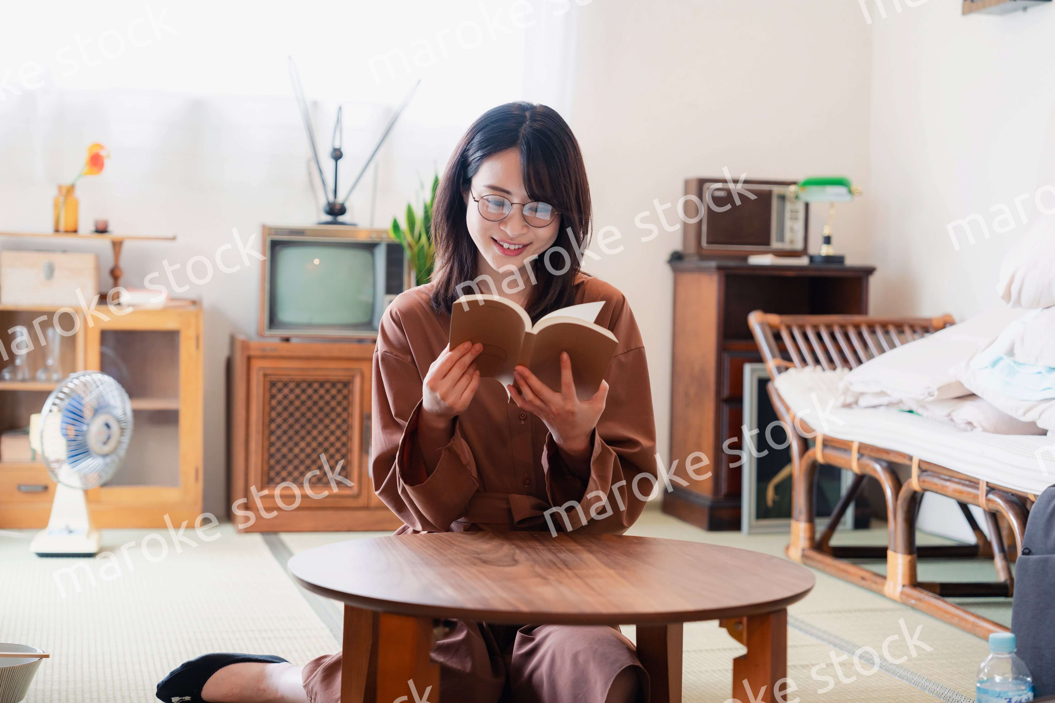 古風な雰囲気の家で読書をする若い女性