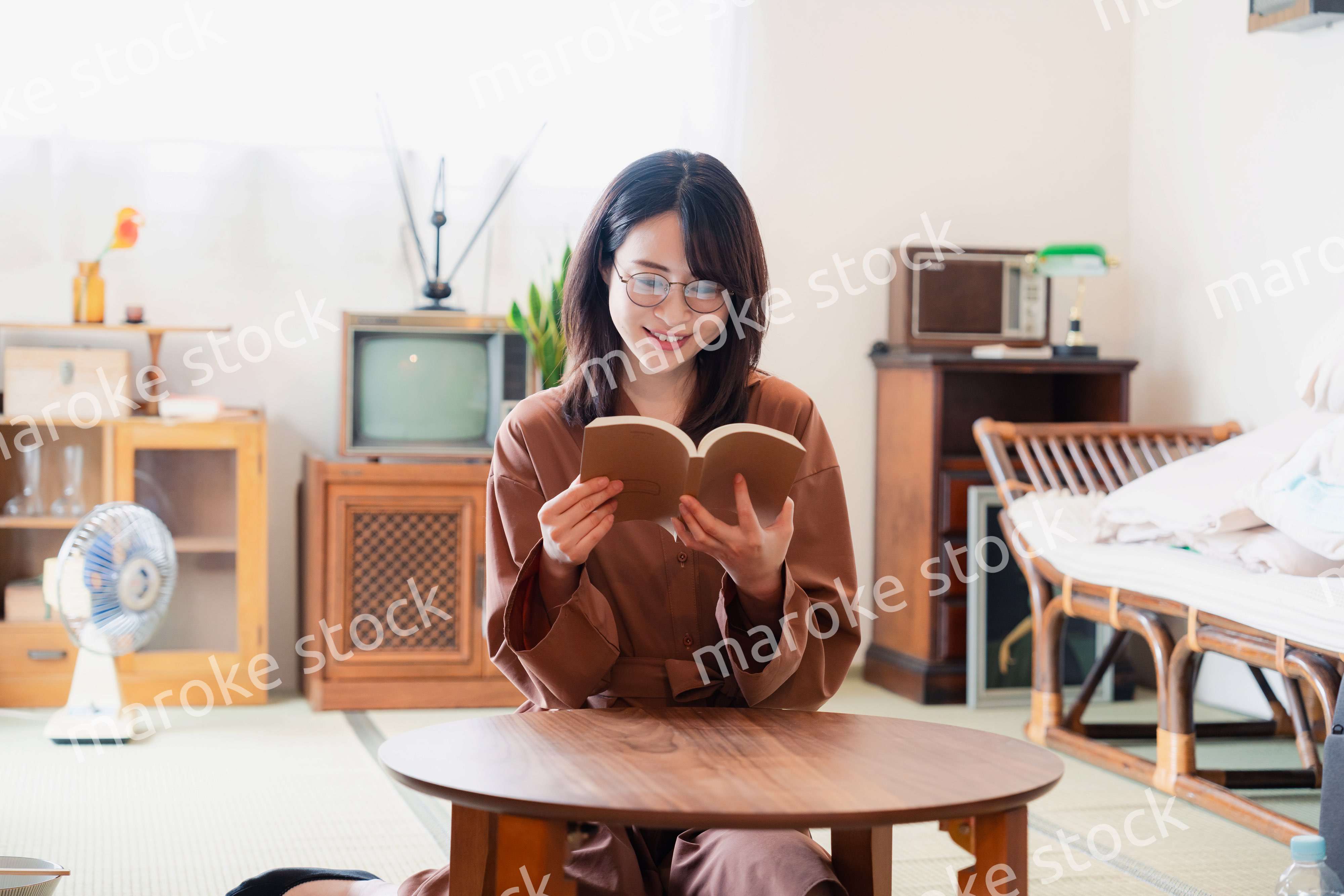 古風な雰囲気の家で読書をする若い女性