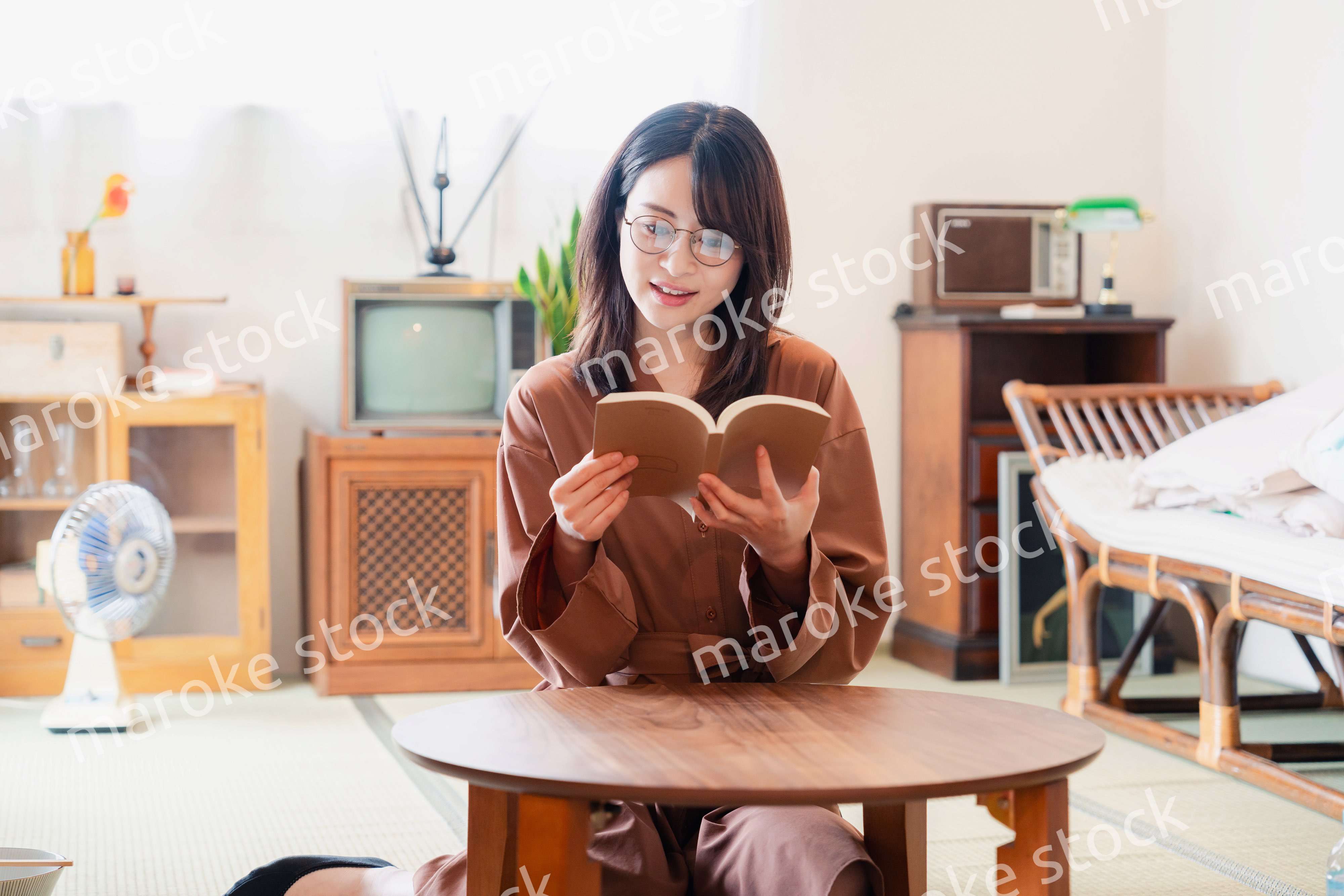 古風な雰囲気の家で読書をする若い女性