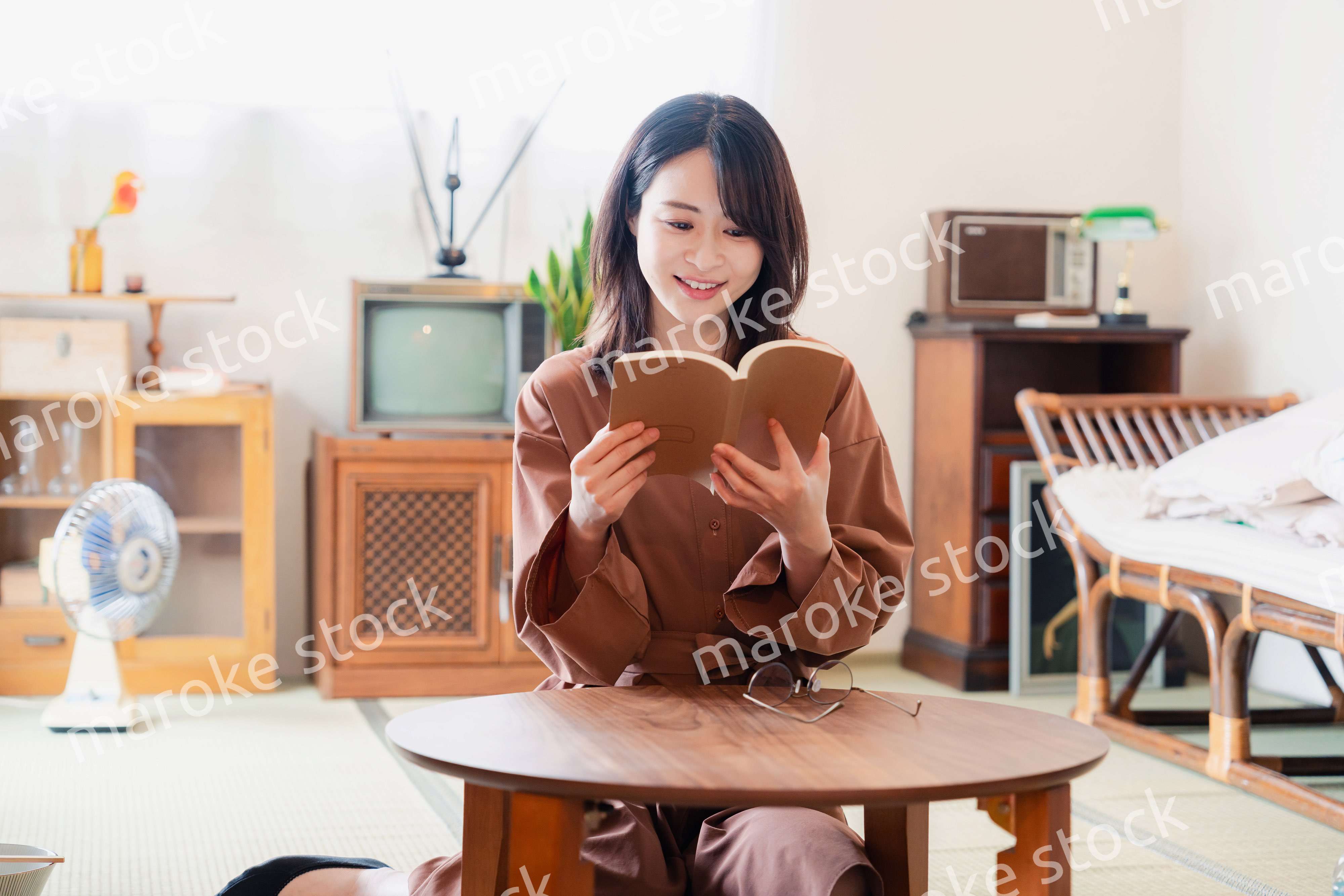 古風な雰囲気の家で読書をする若い女性