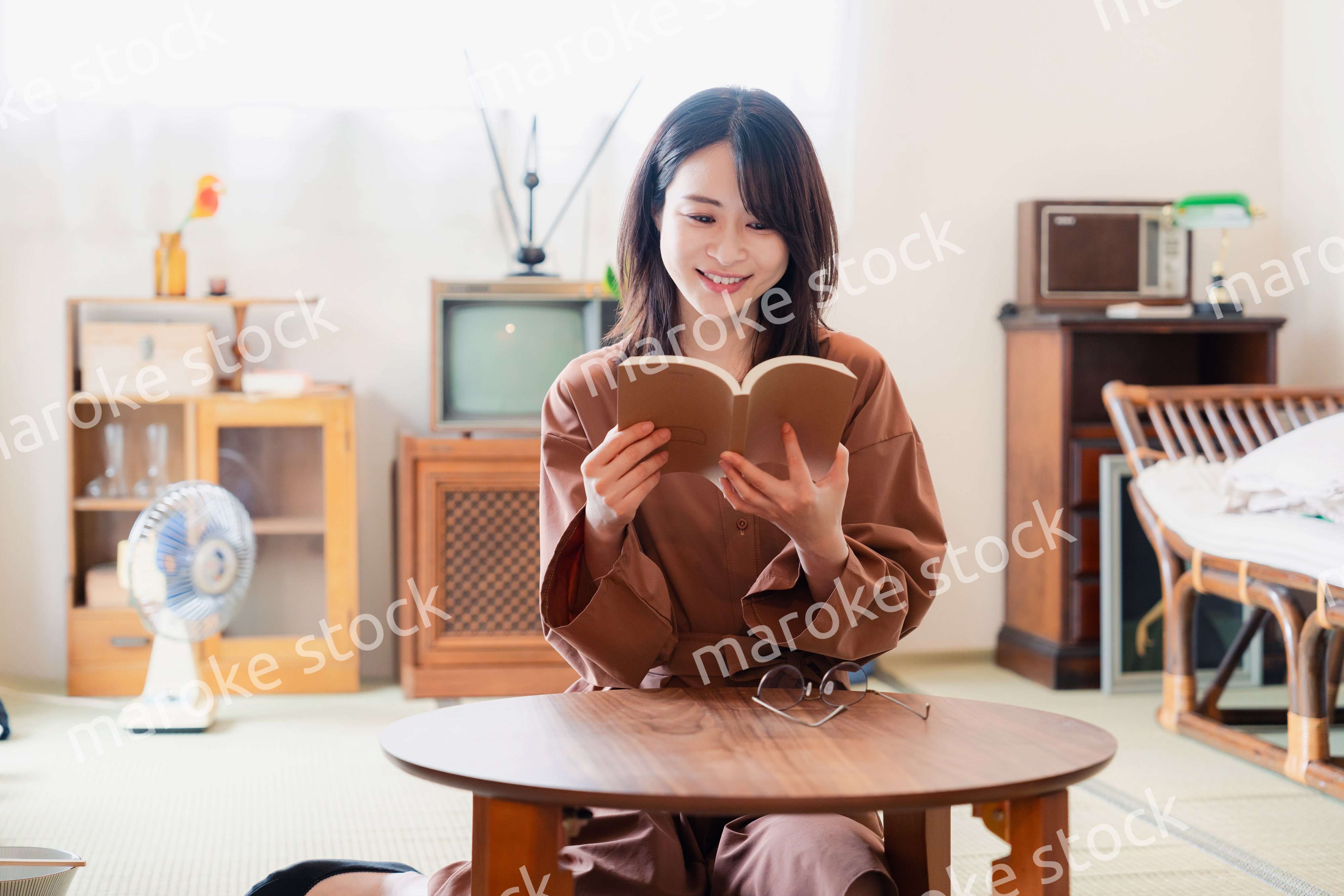 古風な雰囲気の家で読書をする若い女性