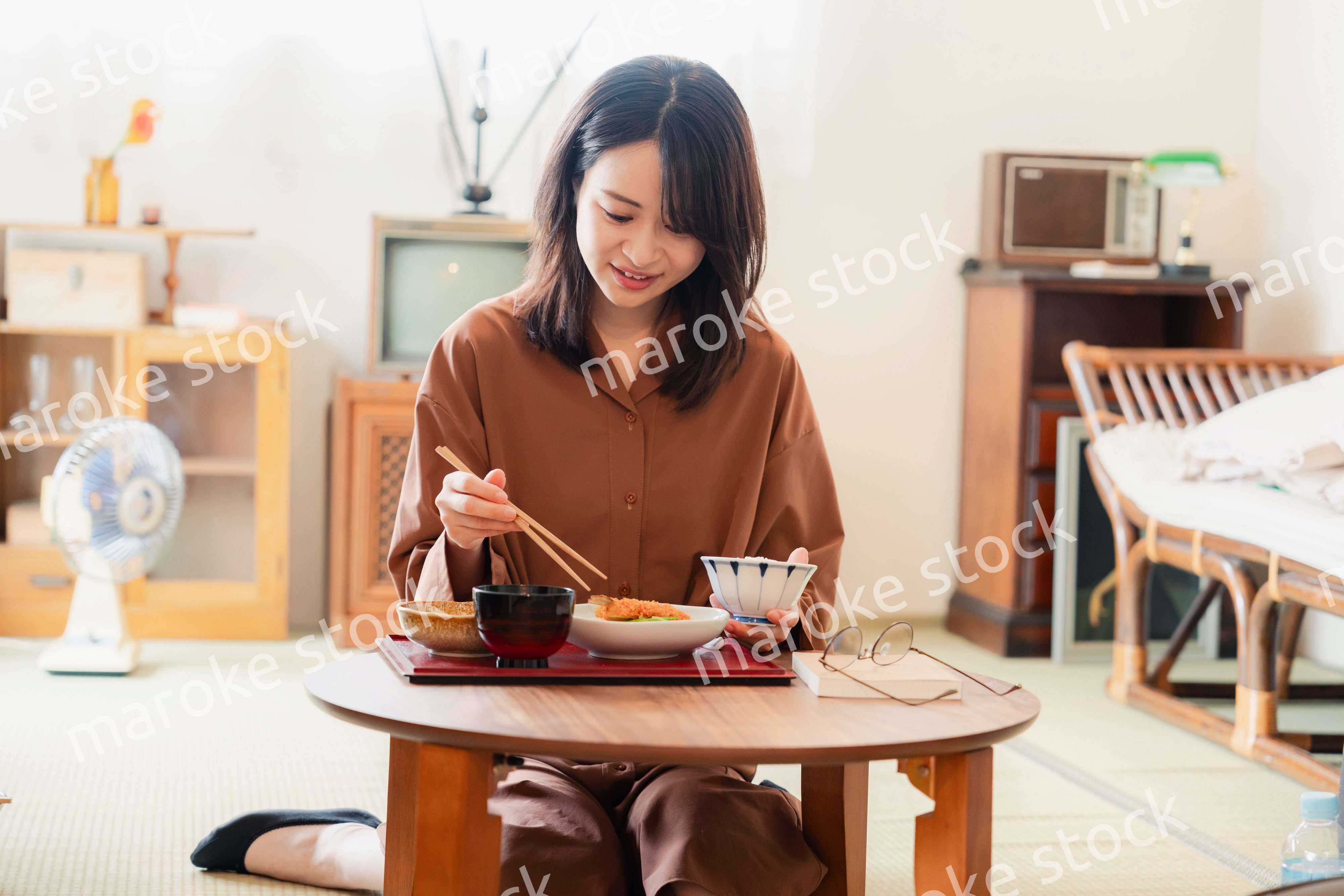 和室でご飯を食べる若い女性