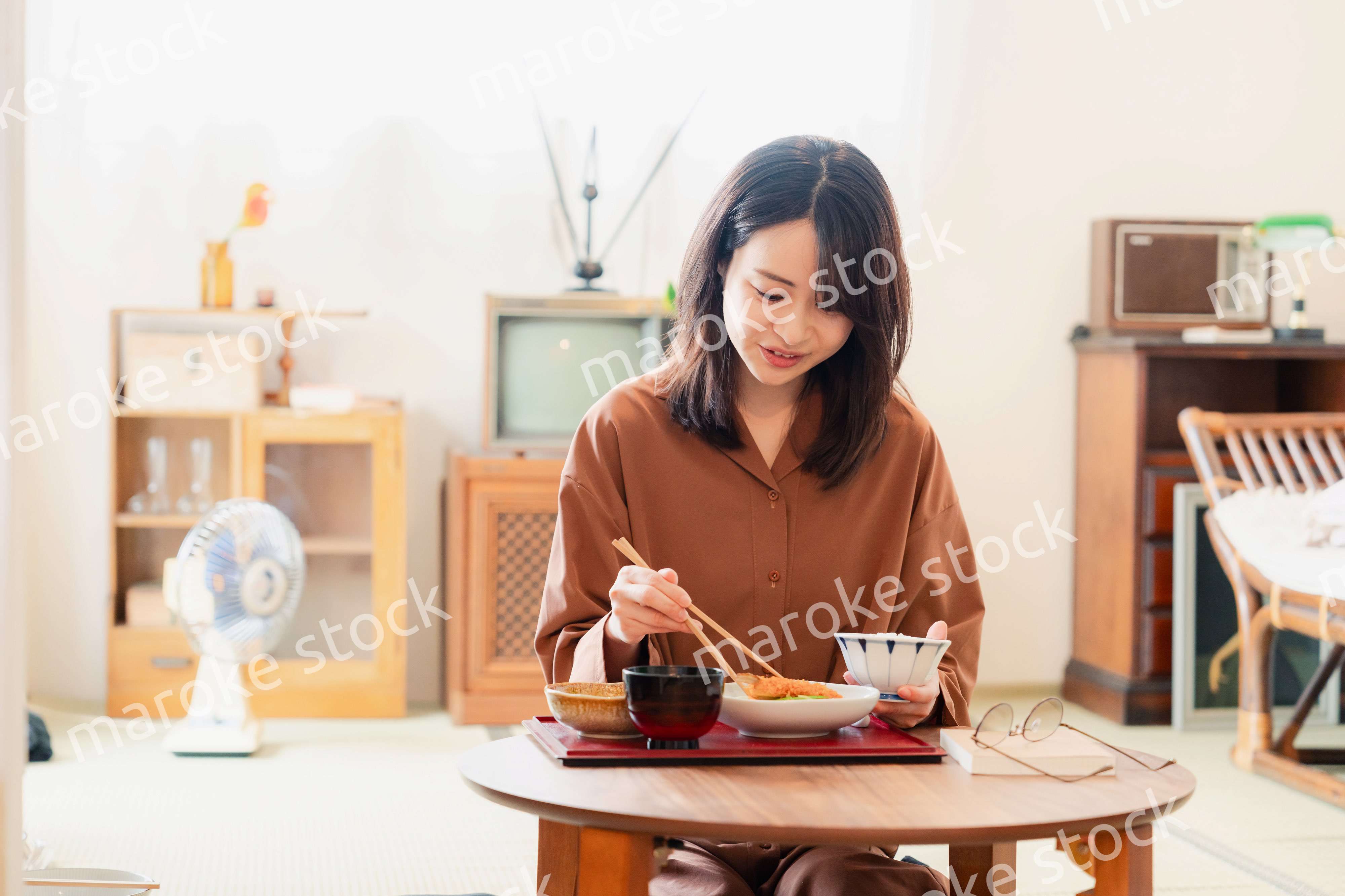 和室でご飯を食べる若い女性