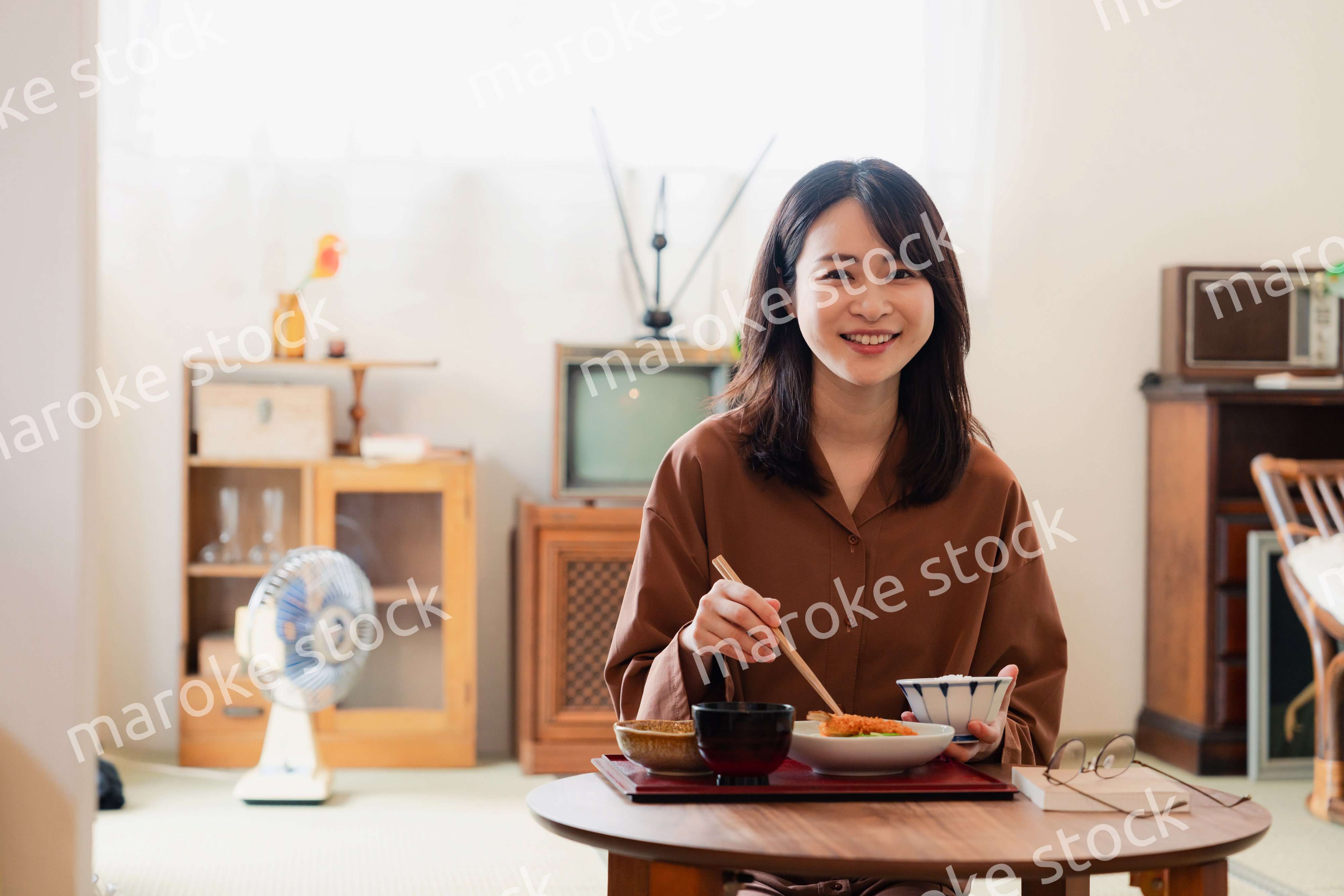 和室でご飯を食べる若い女性