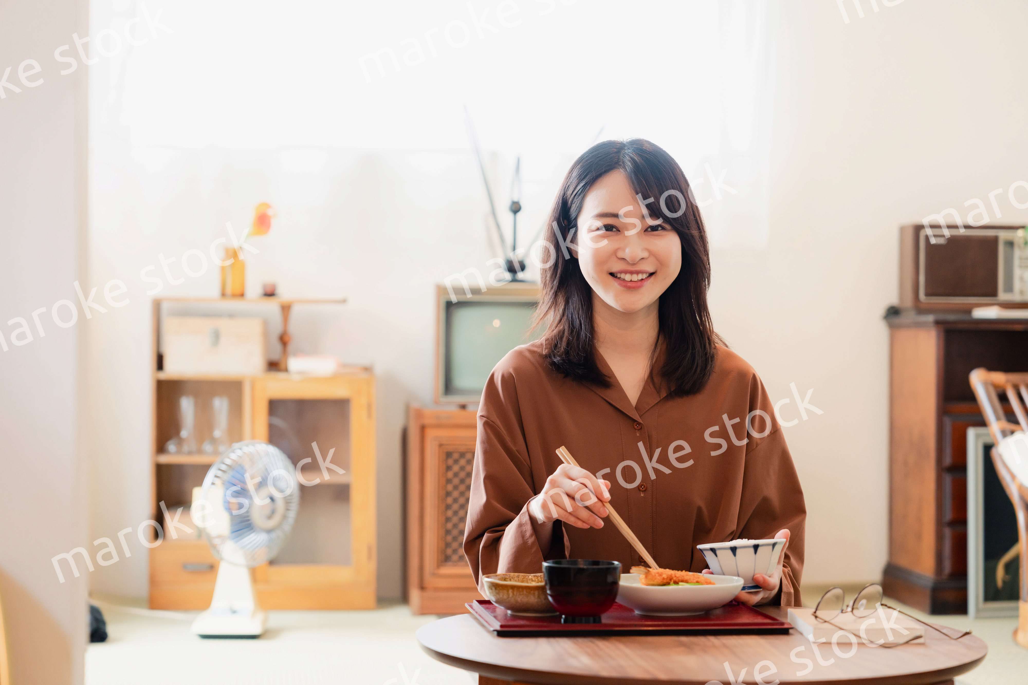和室でご飯を食べる若い女性