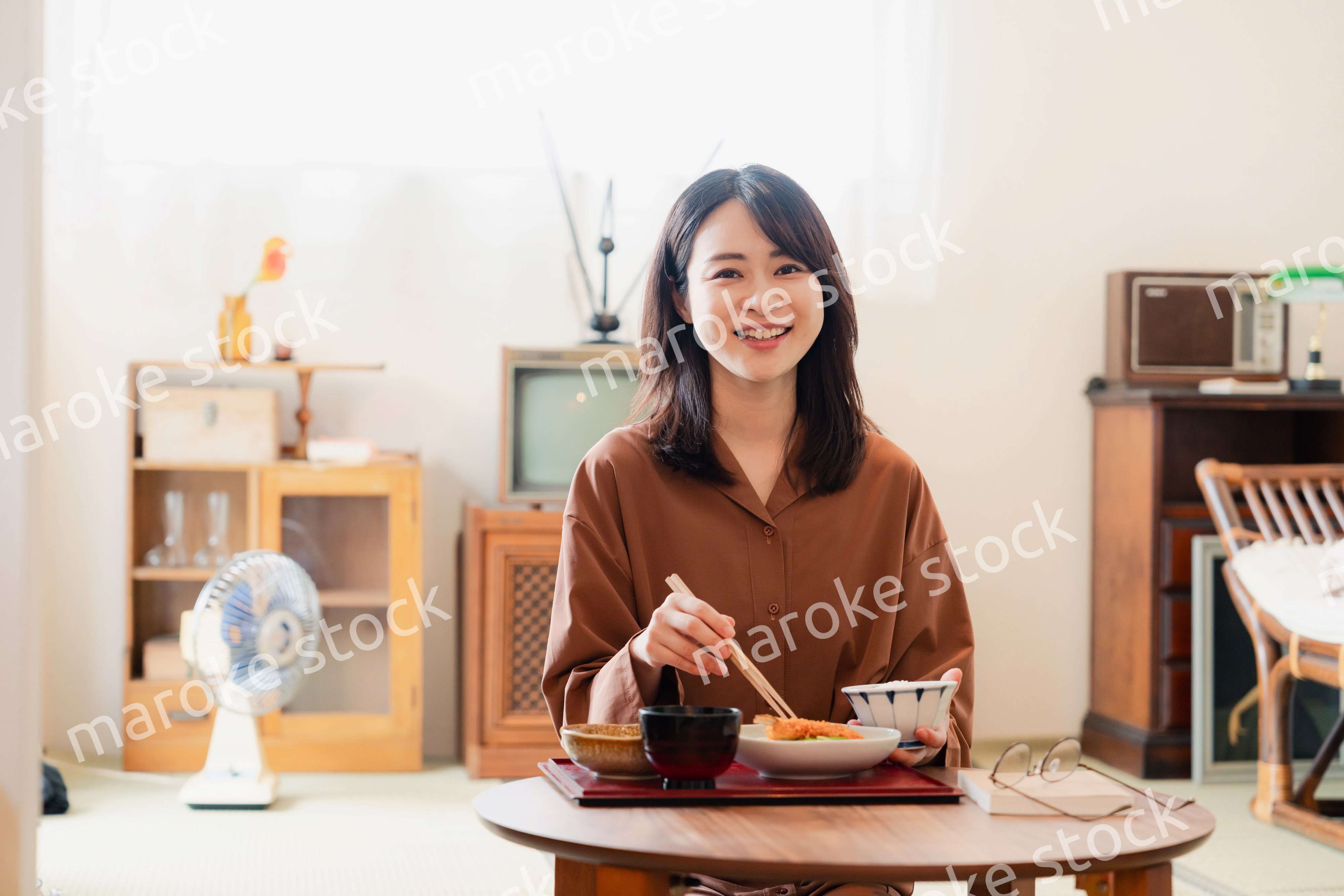 和室でご飯を食べる若い女性