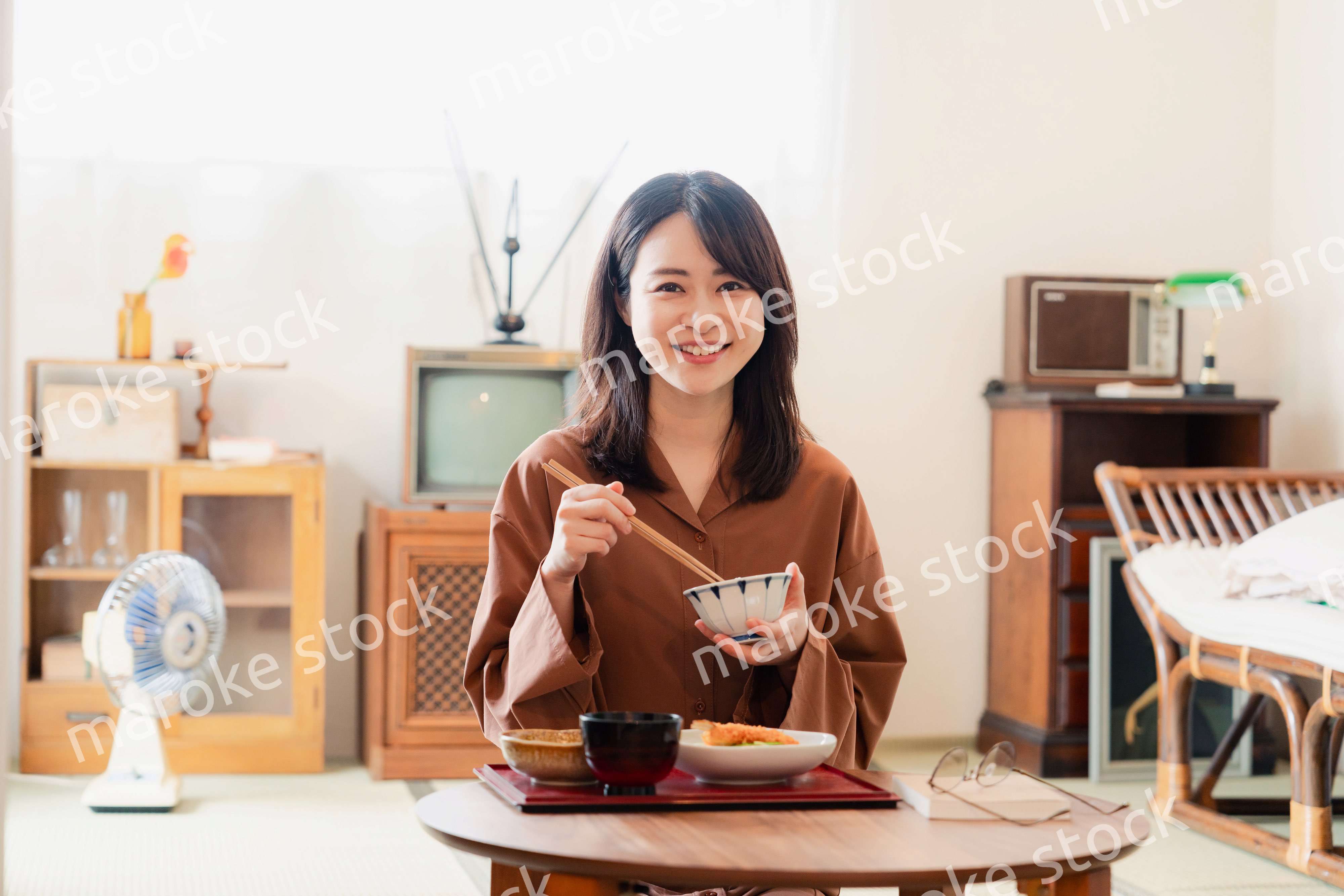 和室でご飯を食べる若い女性