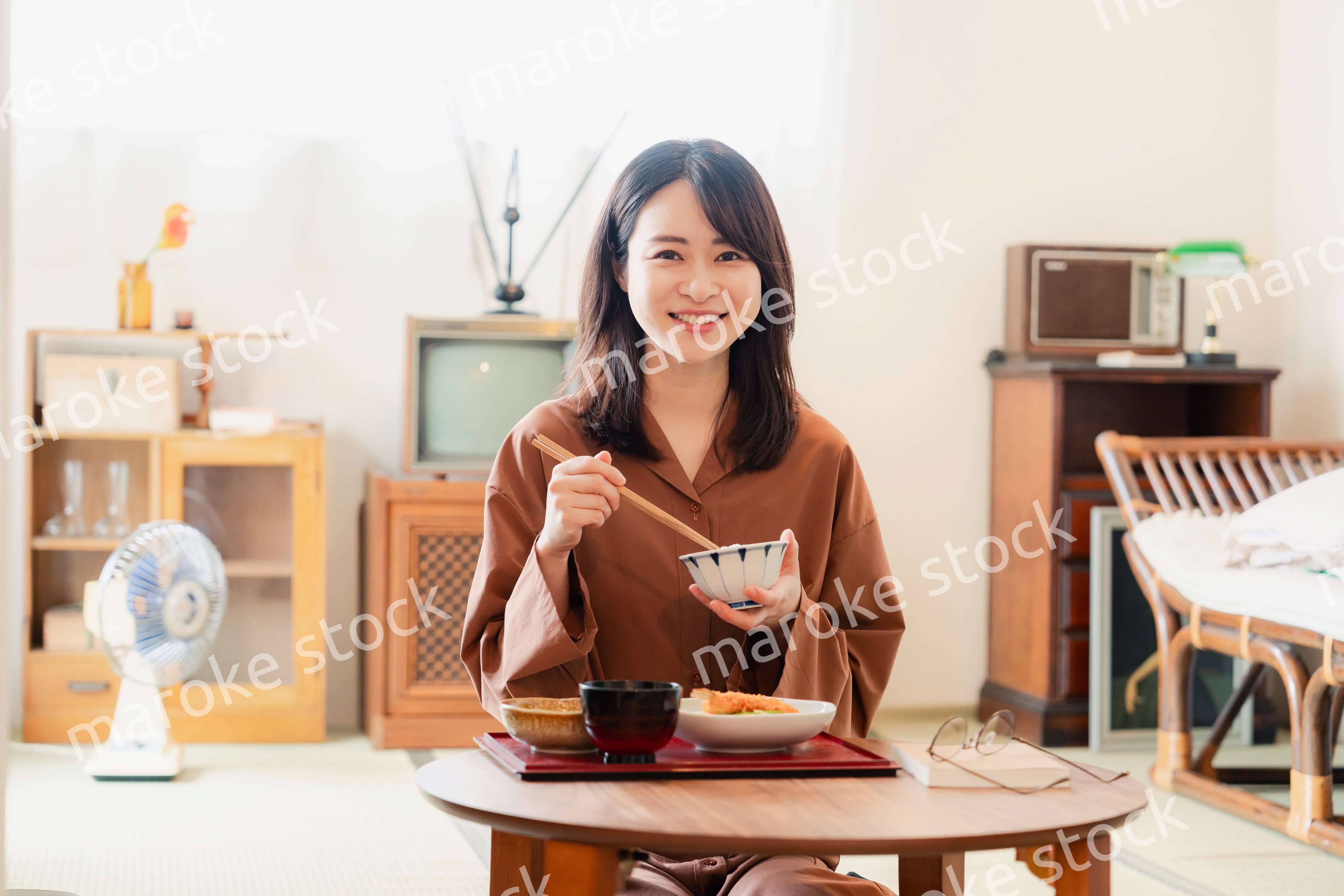 和室でご飯を食べる若い女性