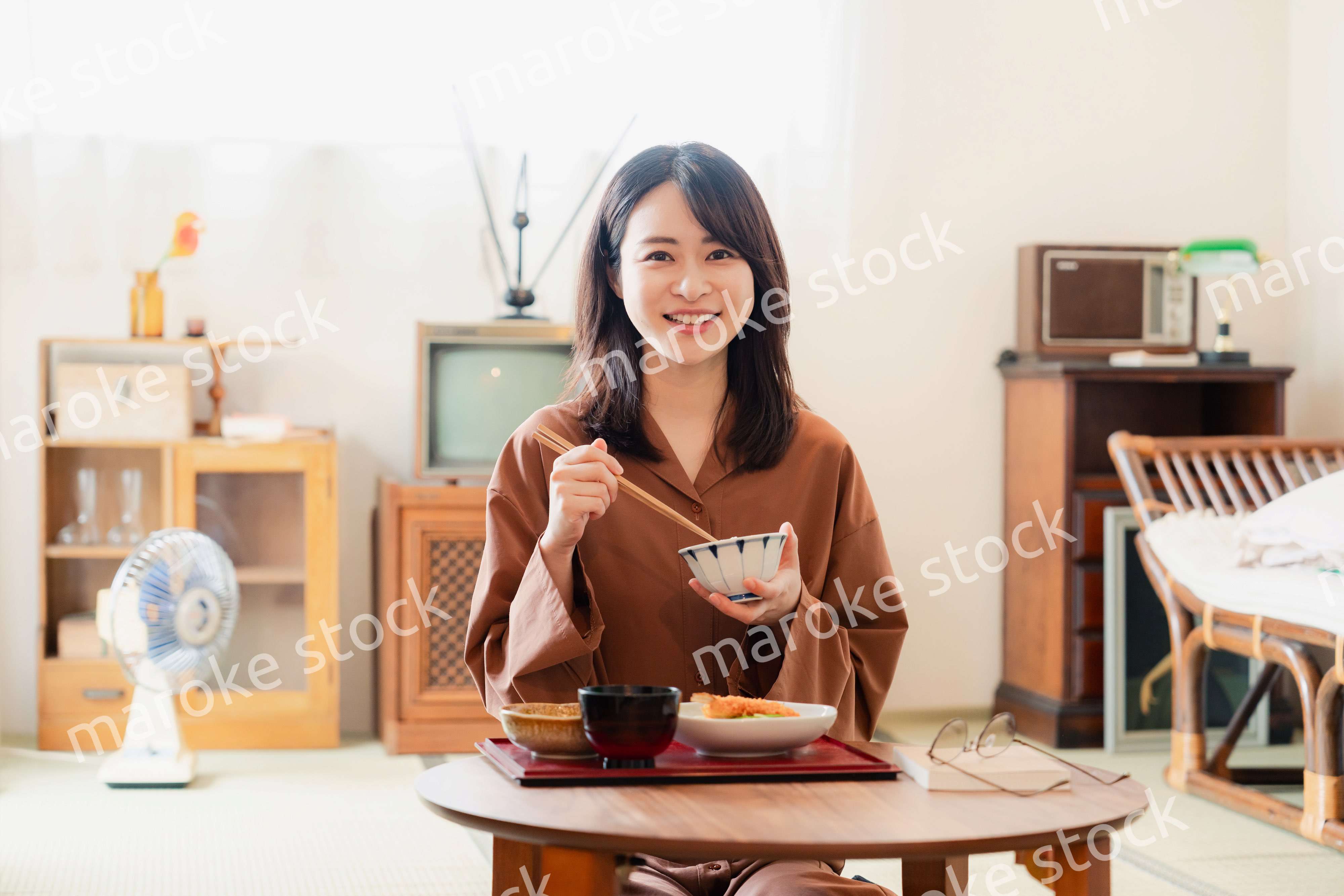 和室でご飯を食べる若い女性