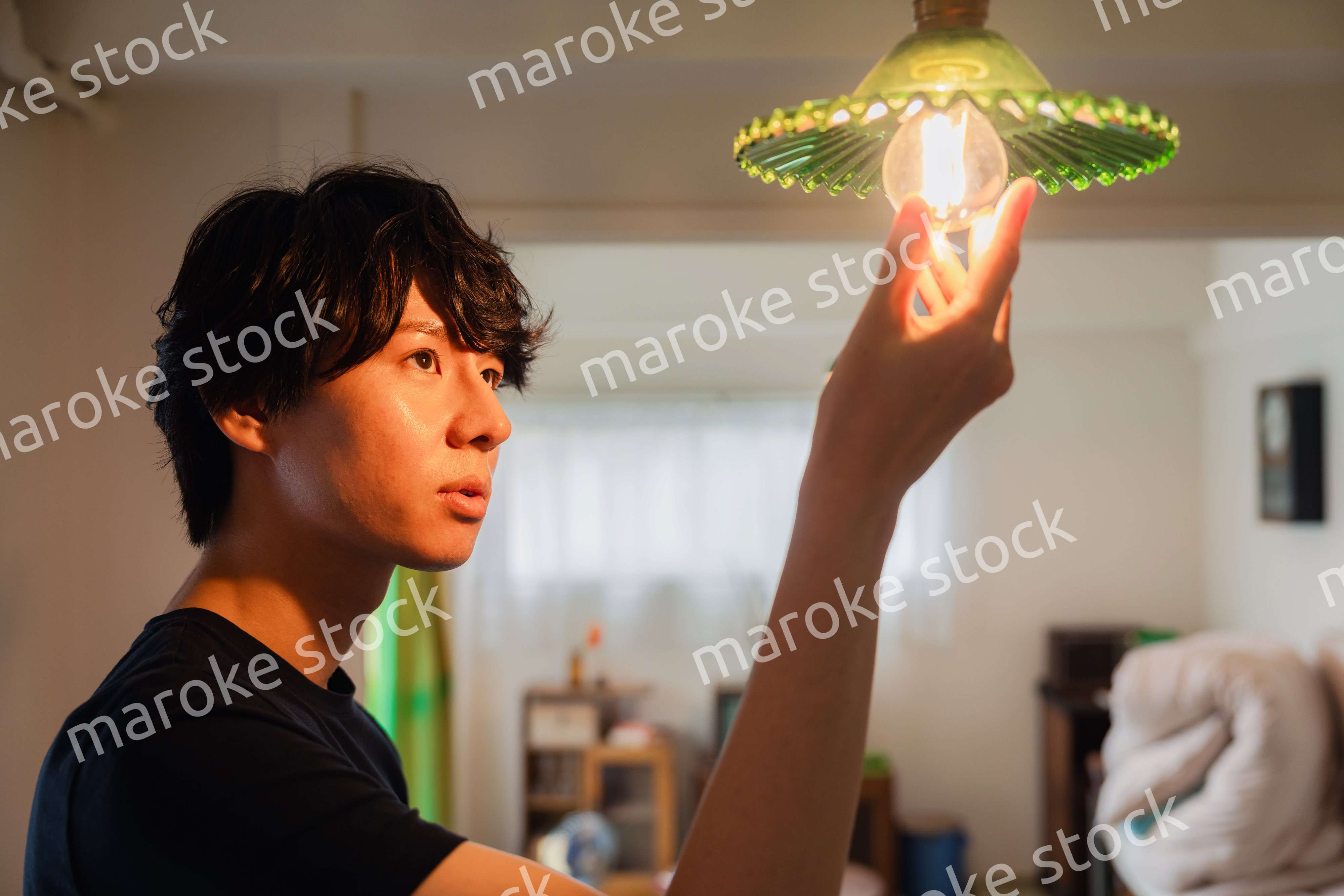 白熱電球を交換する若い男性