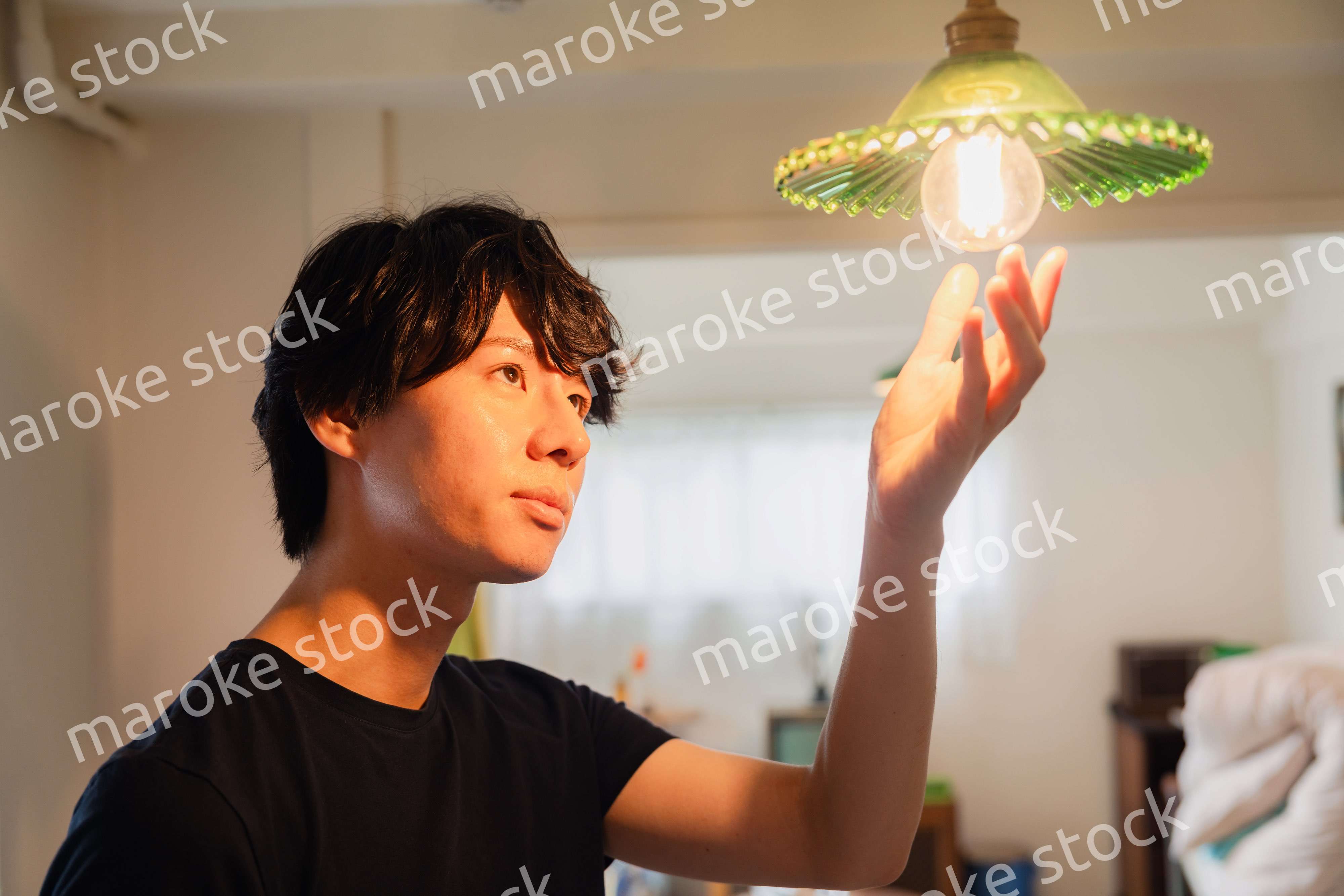 白熱電球を交換する若い男性