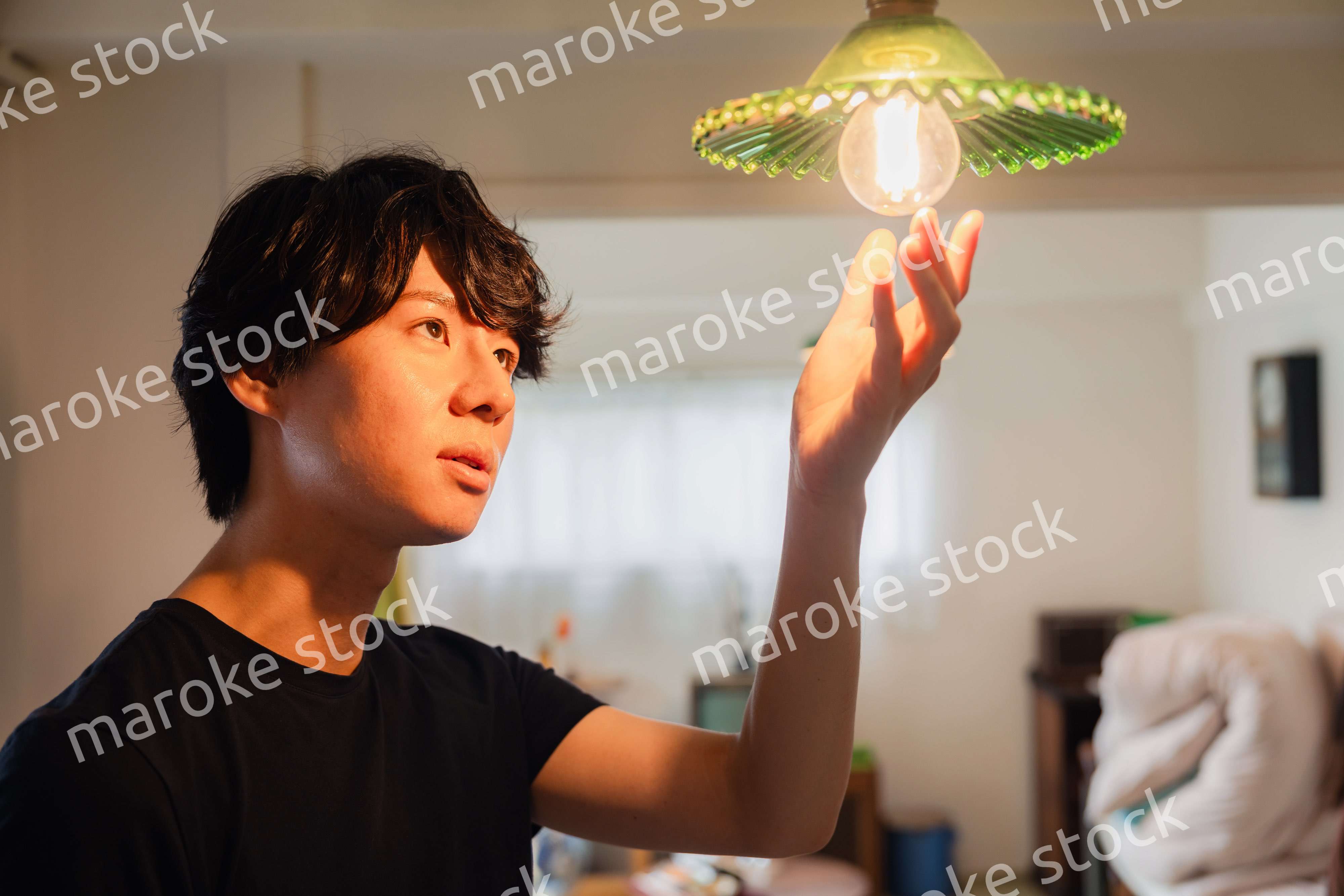 白熱電球を交換する若い男性