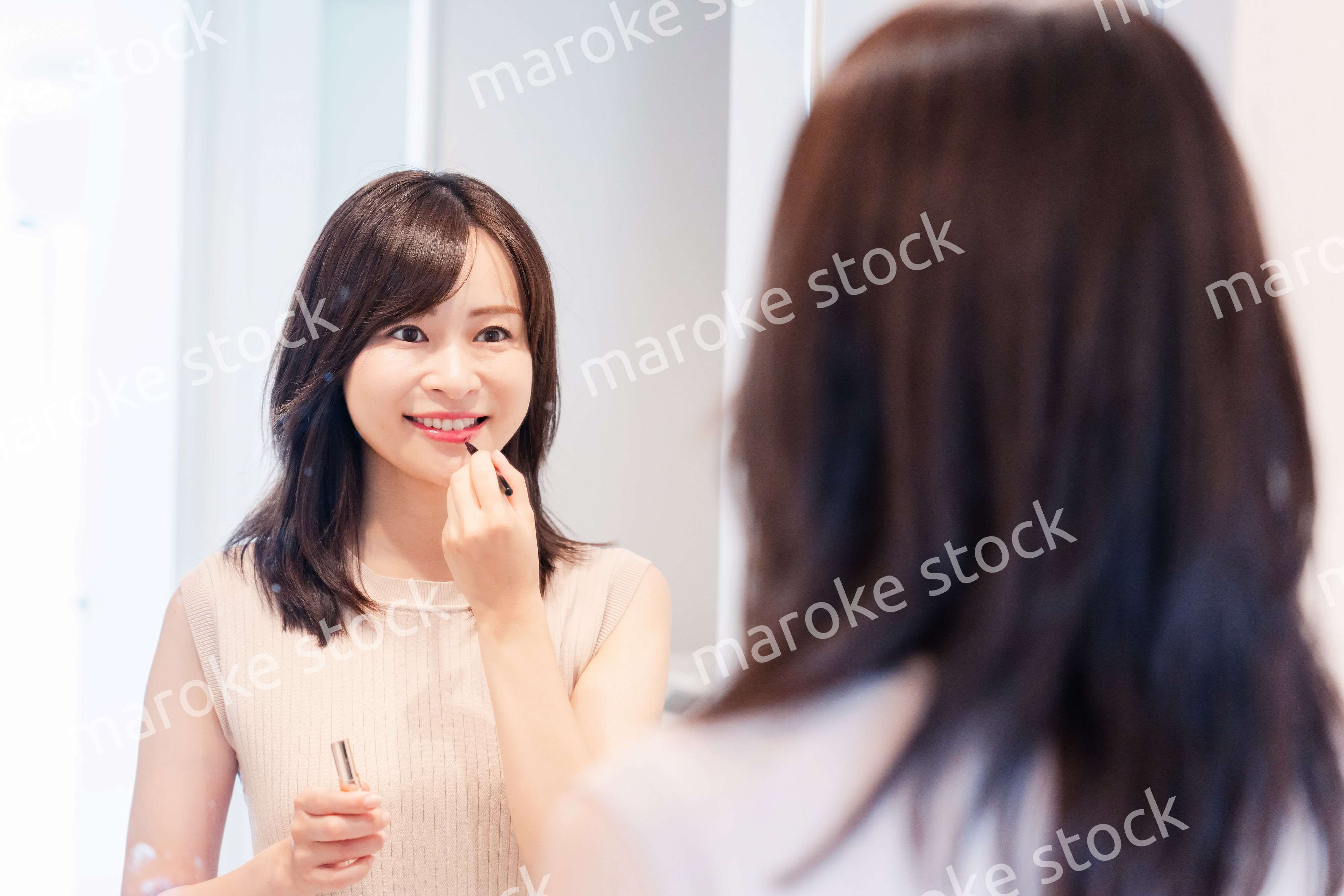 家でメイクをする若い女性