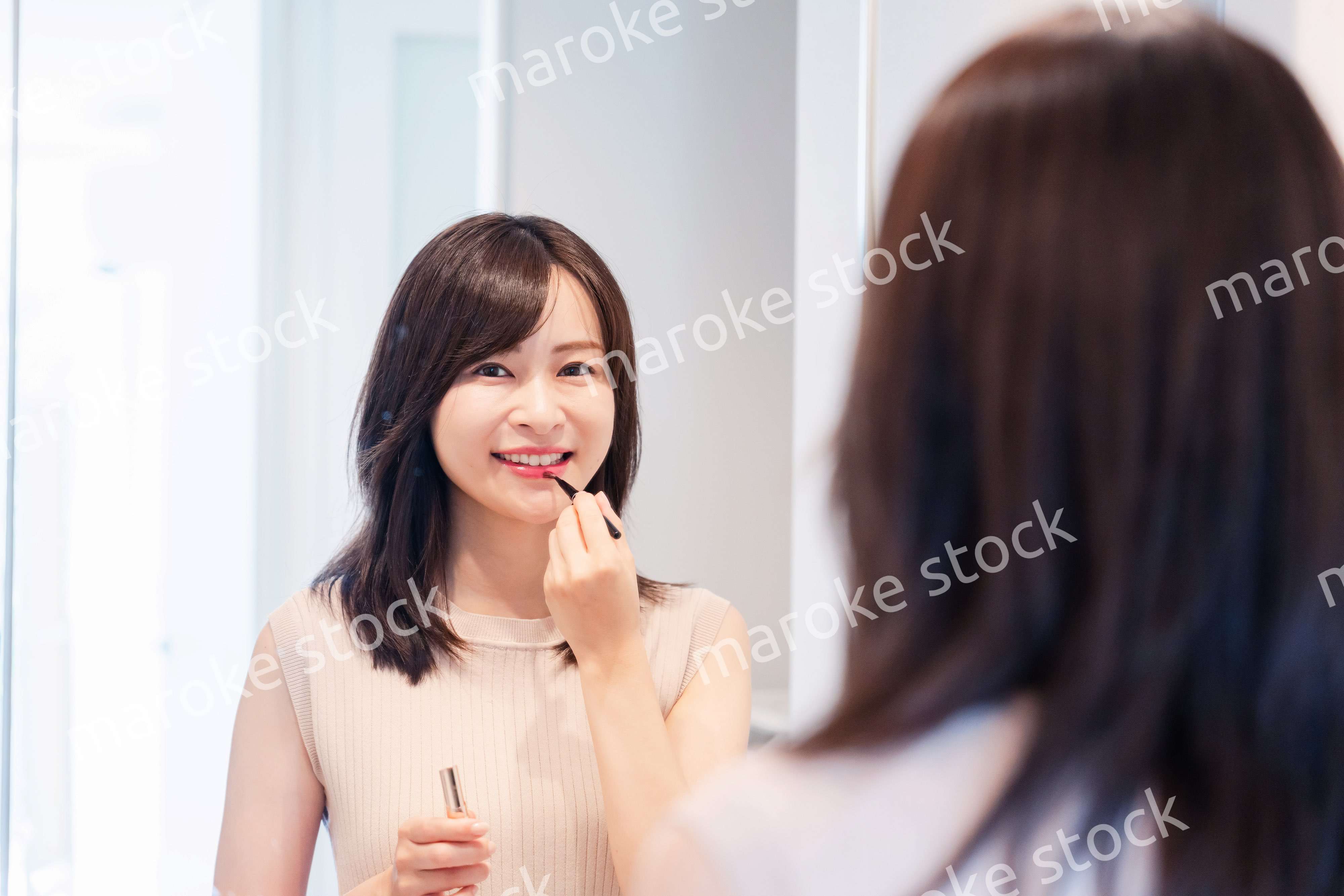 家でメイクをする若い女性