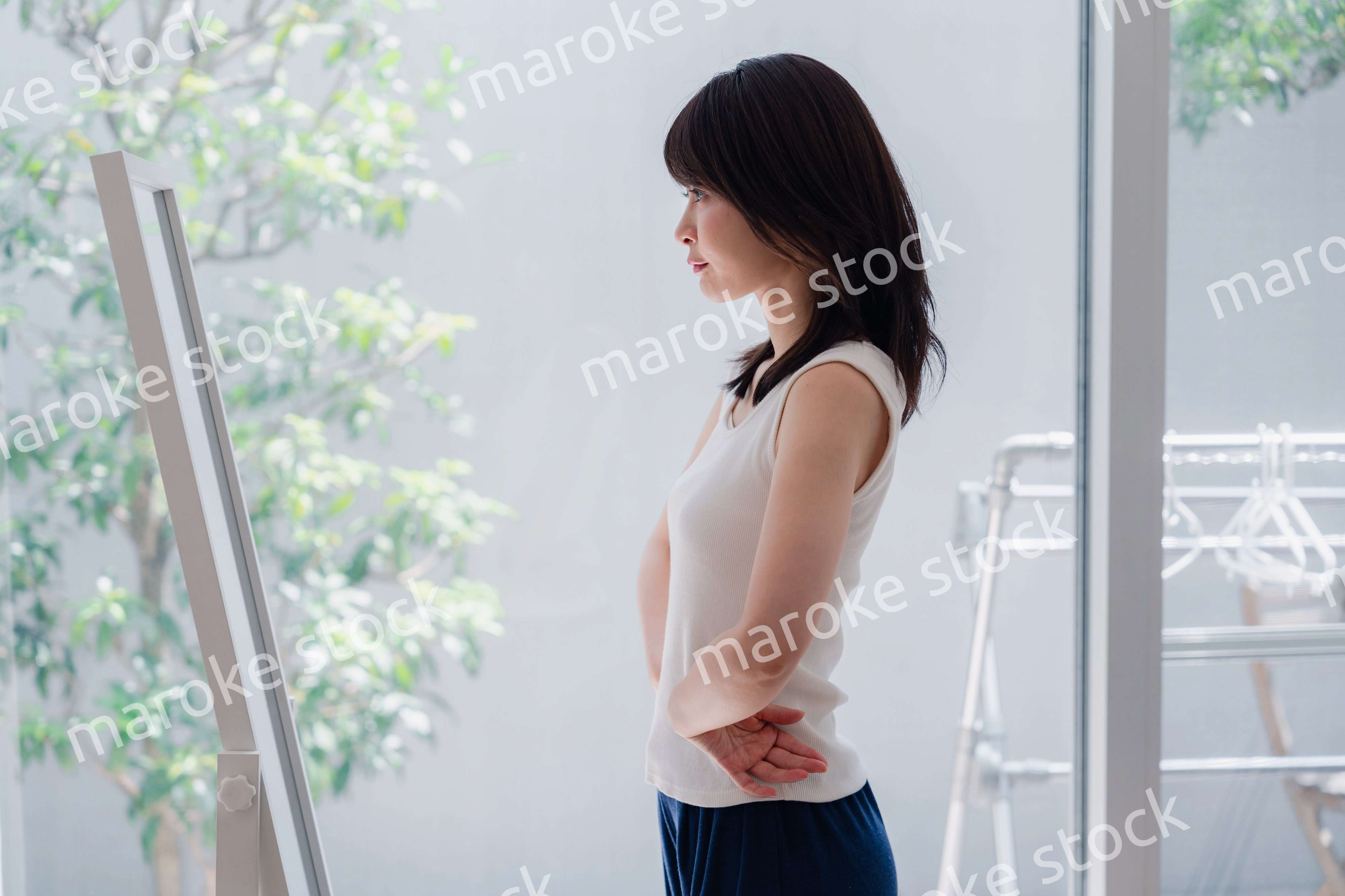 自分の体型を気にする若い女性