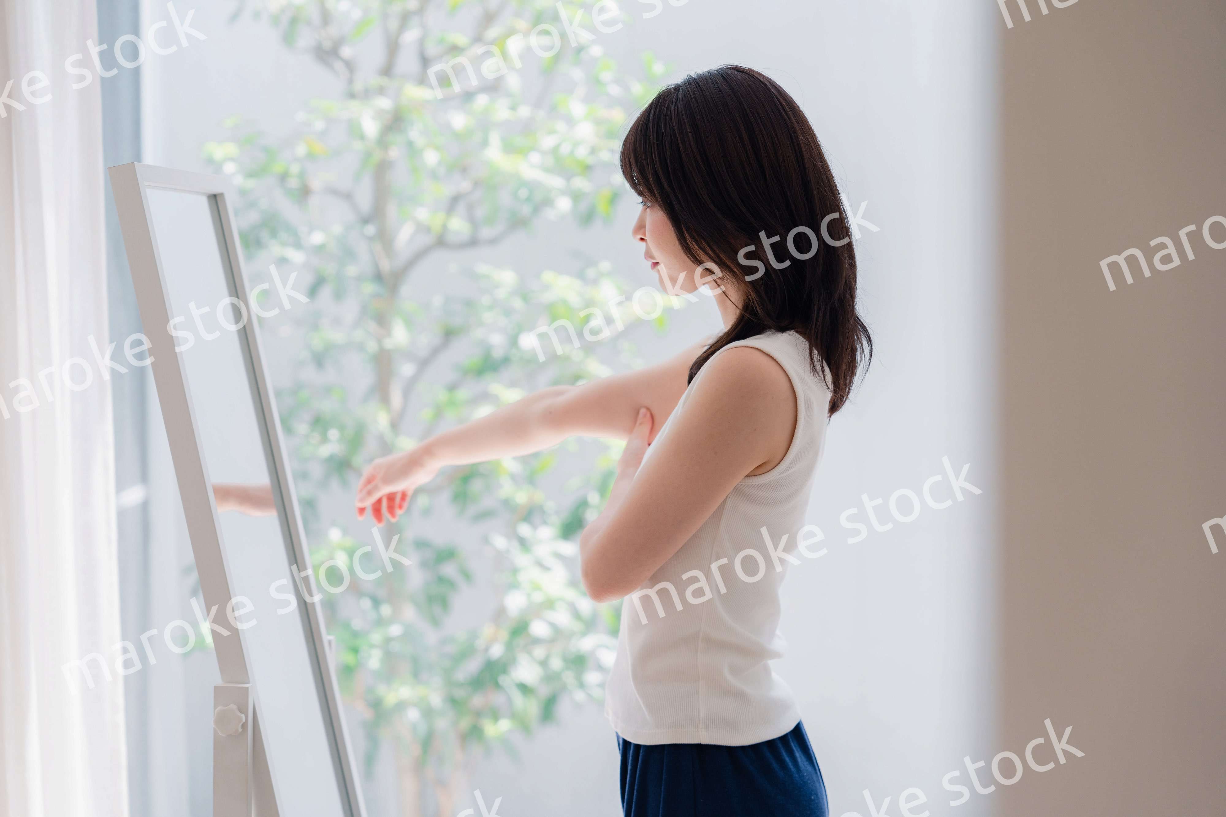 自分の体型を気にする若い女性