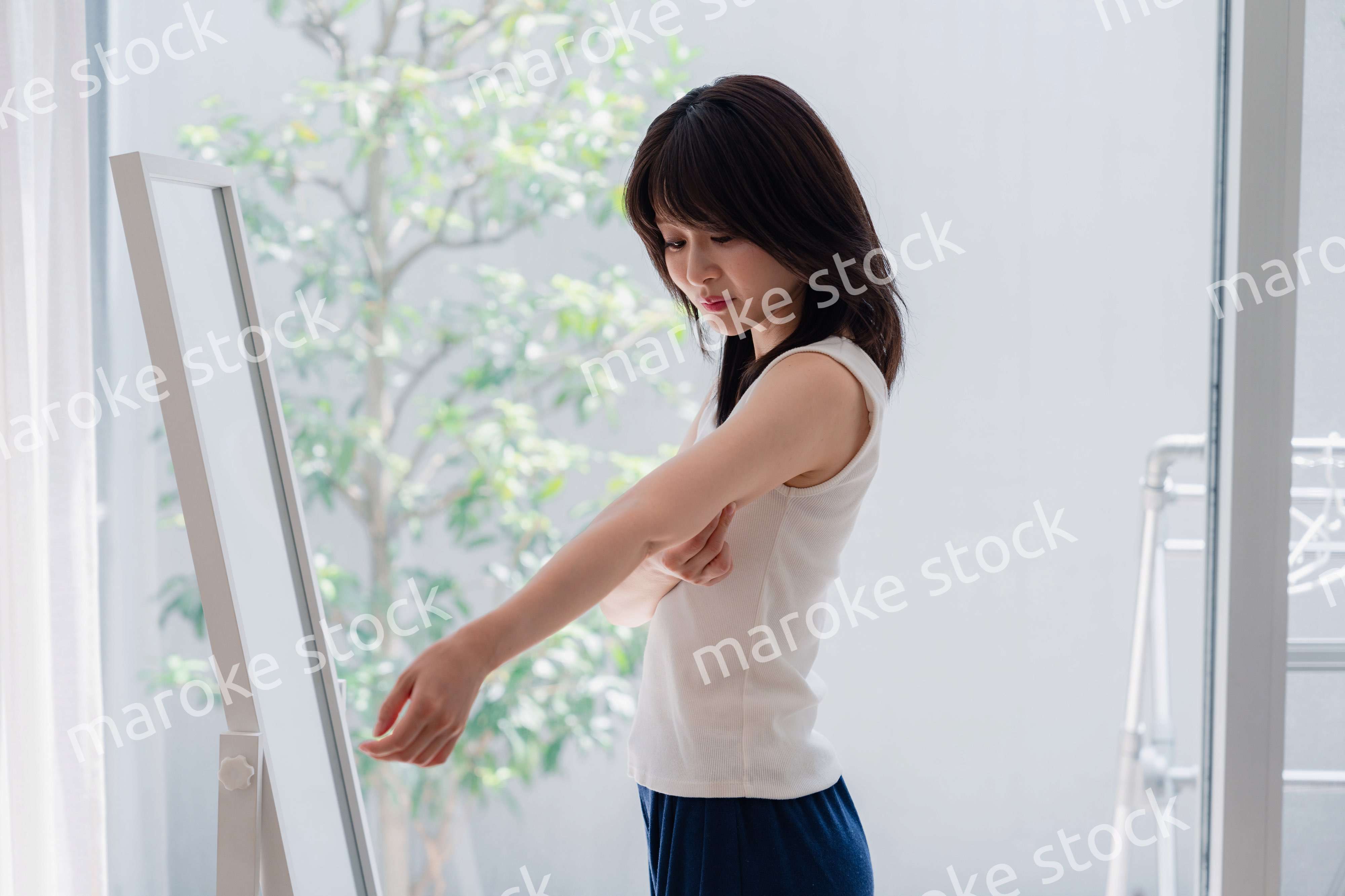 自分の体型を気にする若い女性