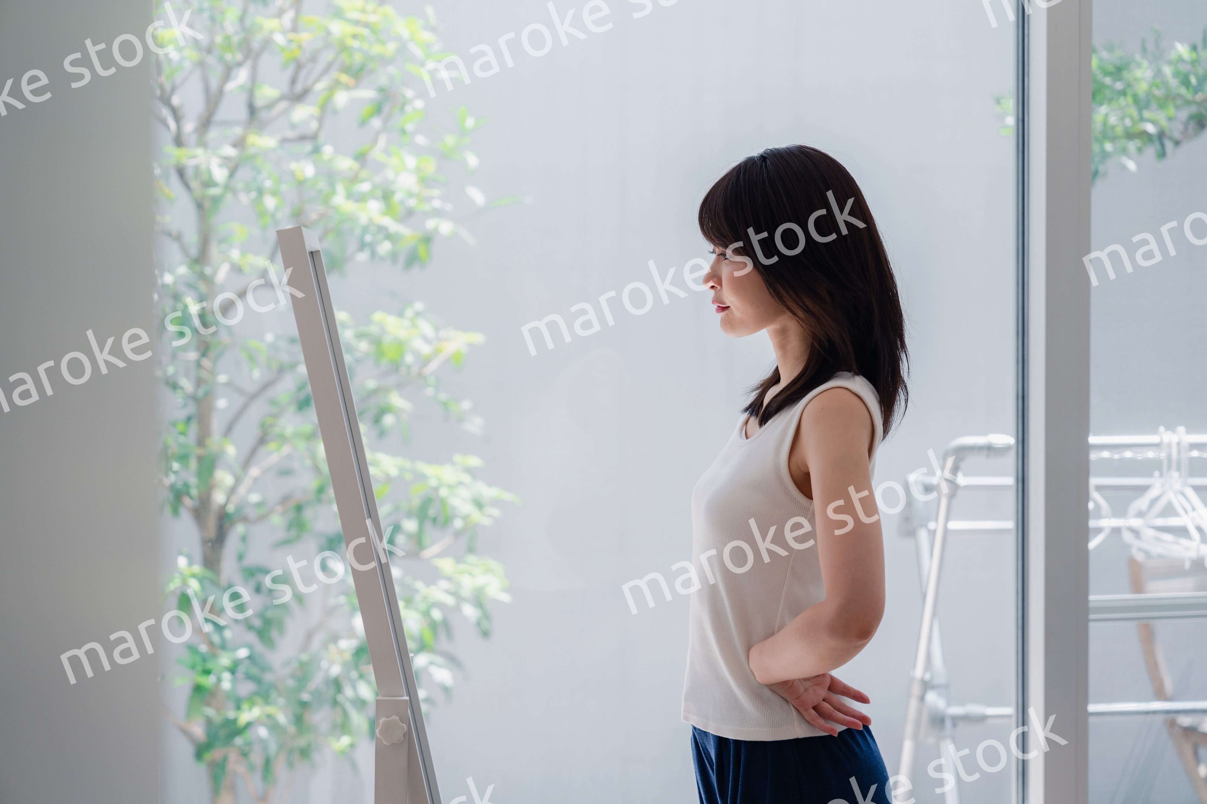 自分の体型を気にする若い女性