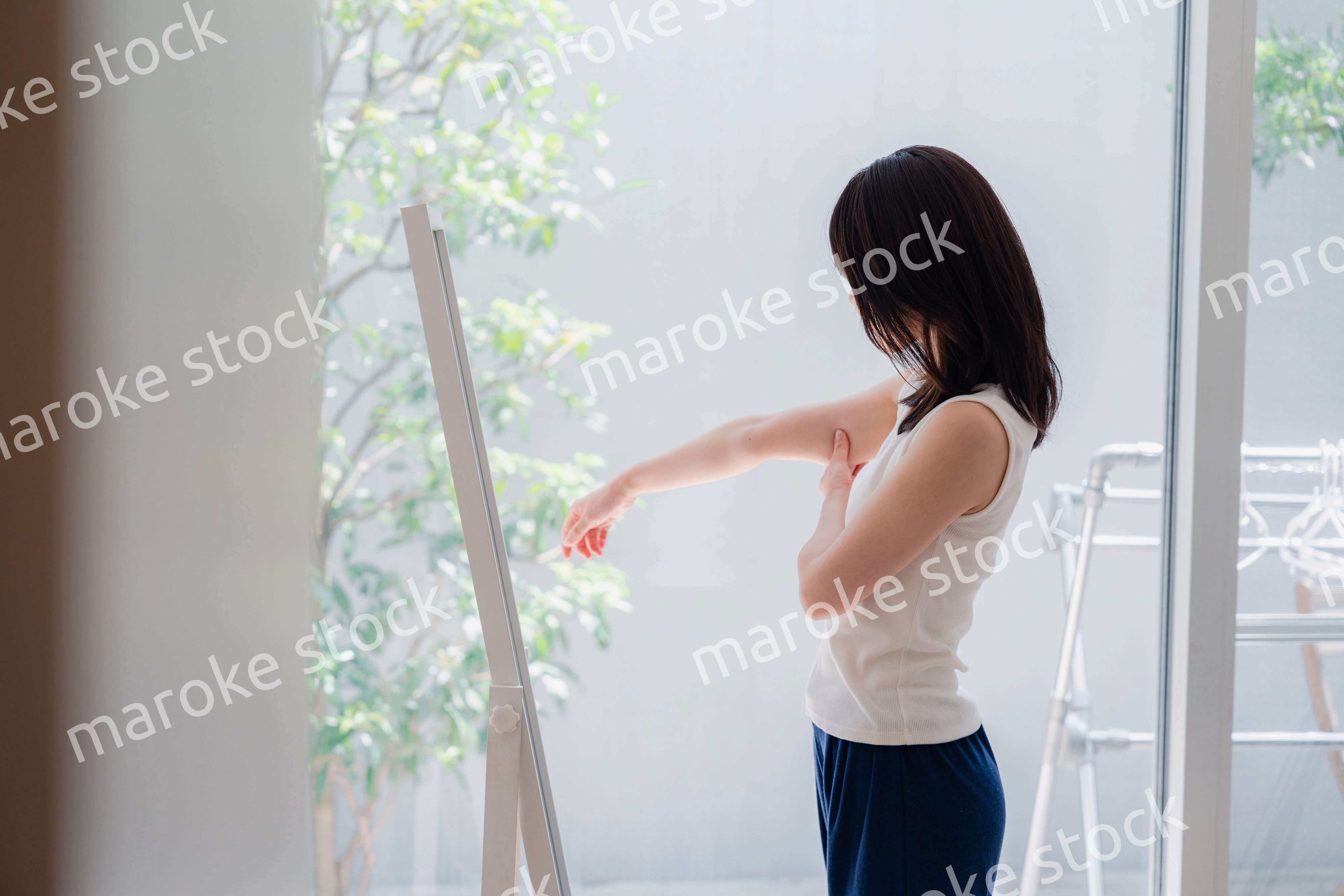 自分の体型を気にする若い女性