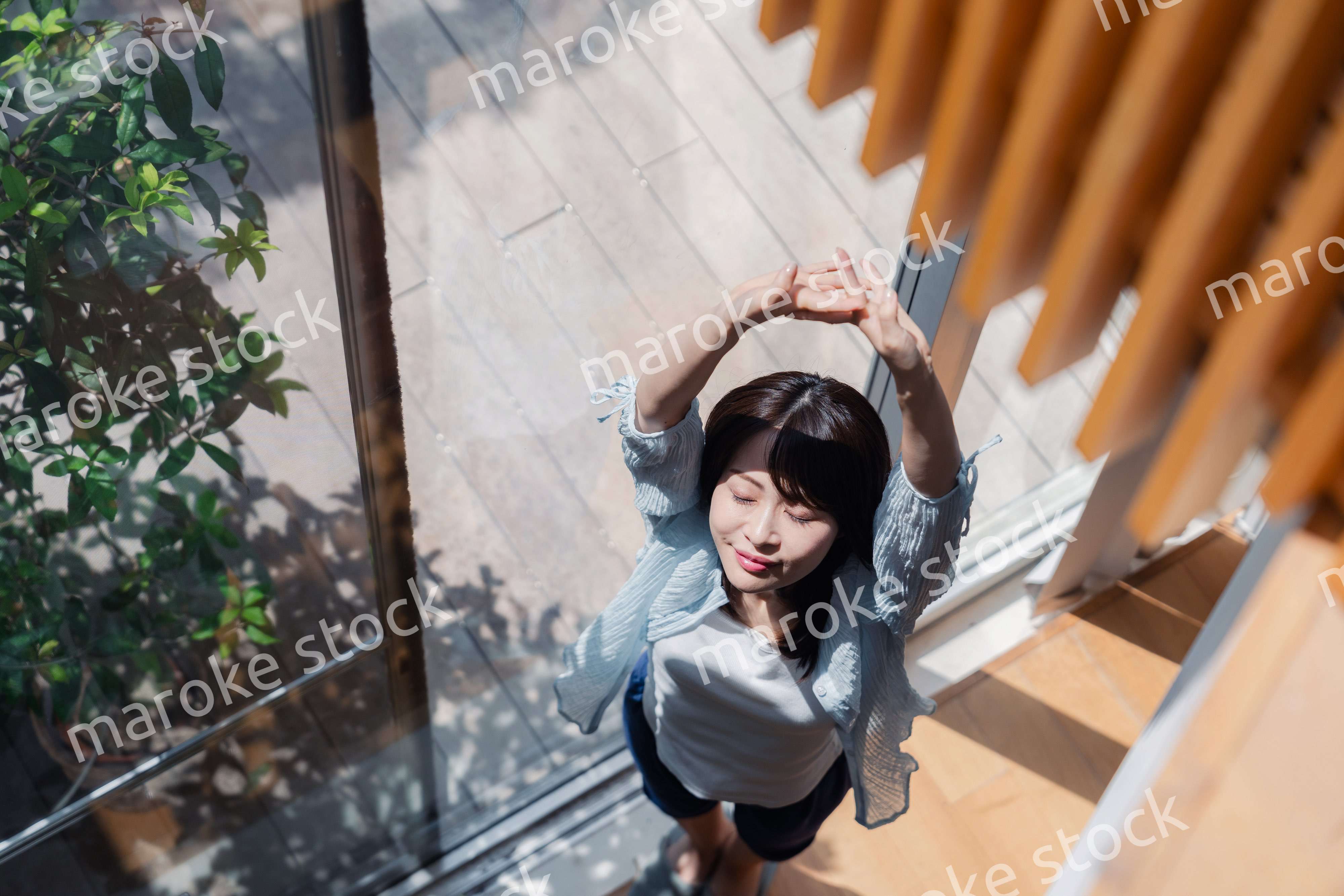 家の窓際で過ごす若い女性