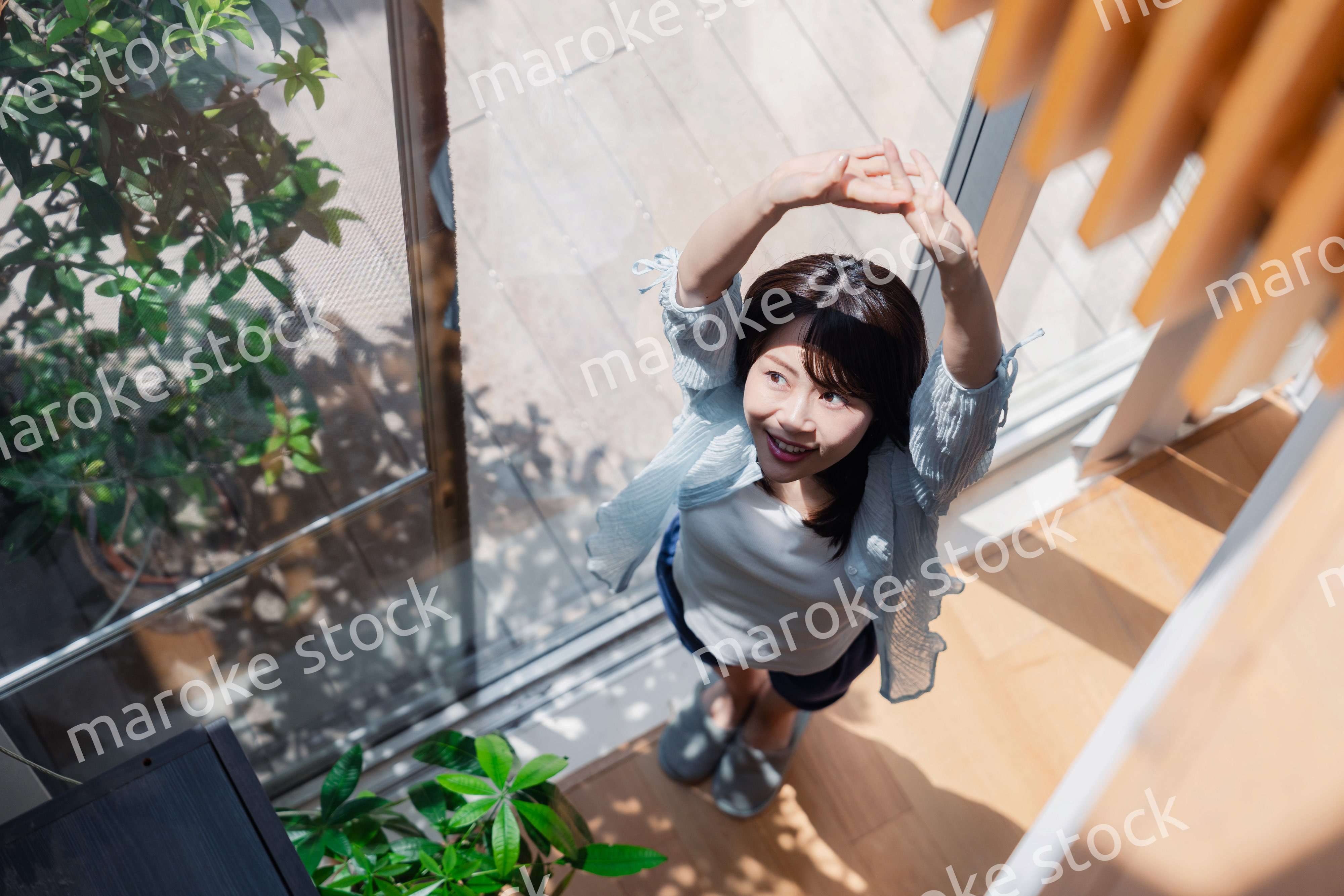 家の窓際で過ごす若い女性