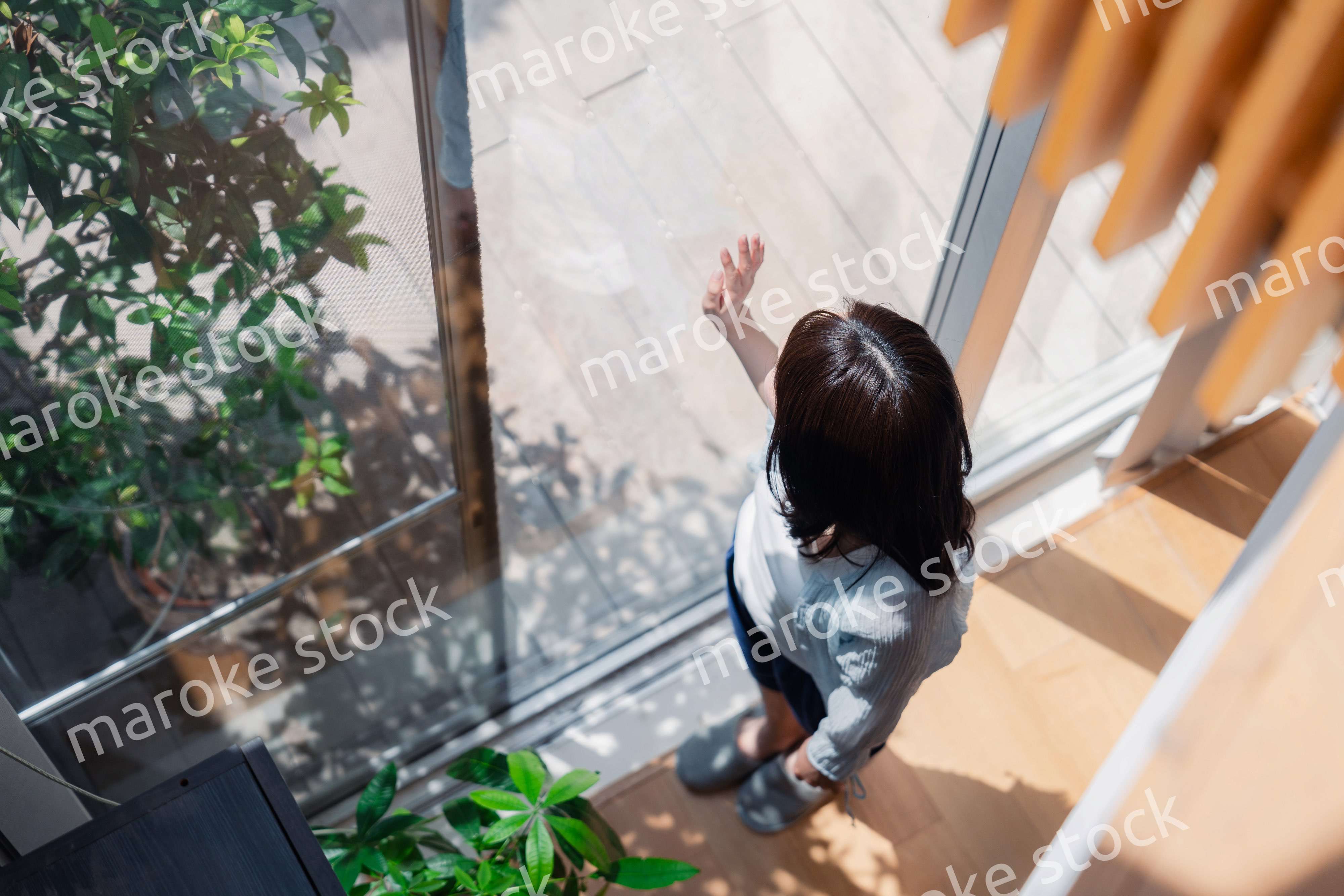 家の窓際で過ごす若い女性