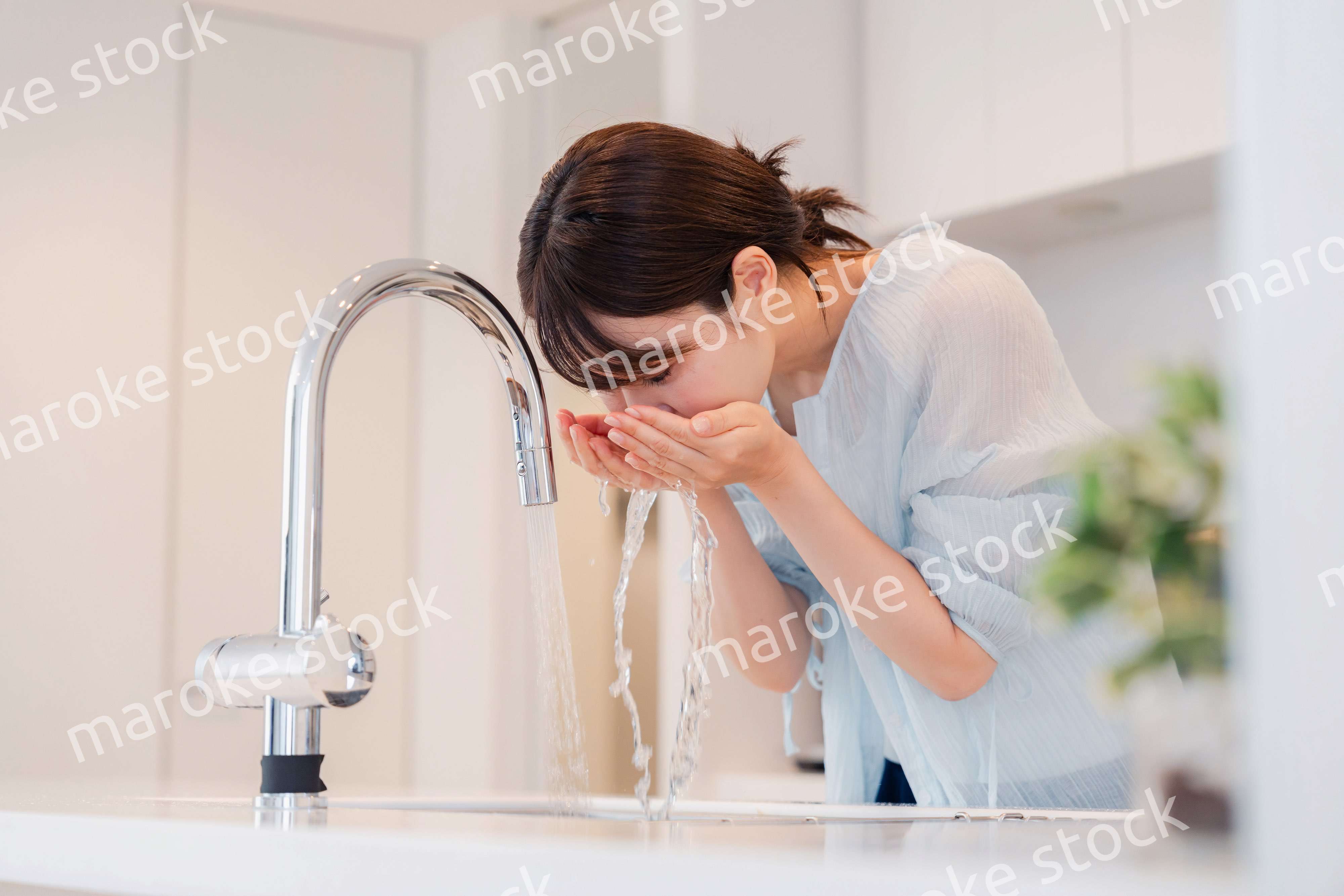 家で洗顔をする若い女性