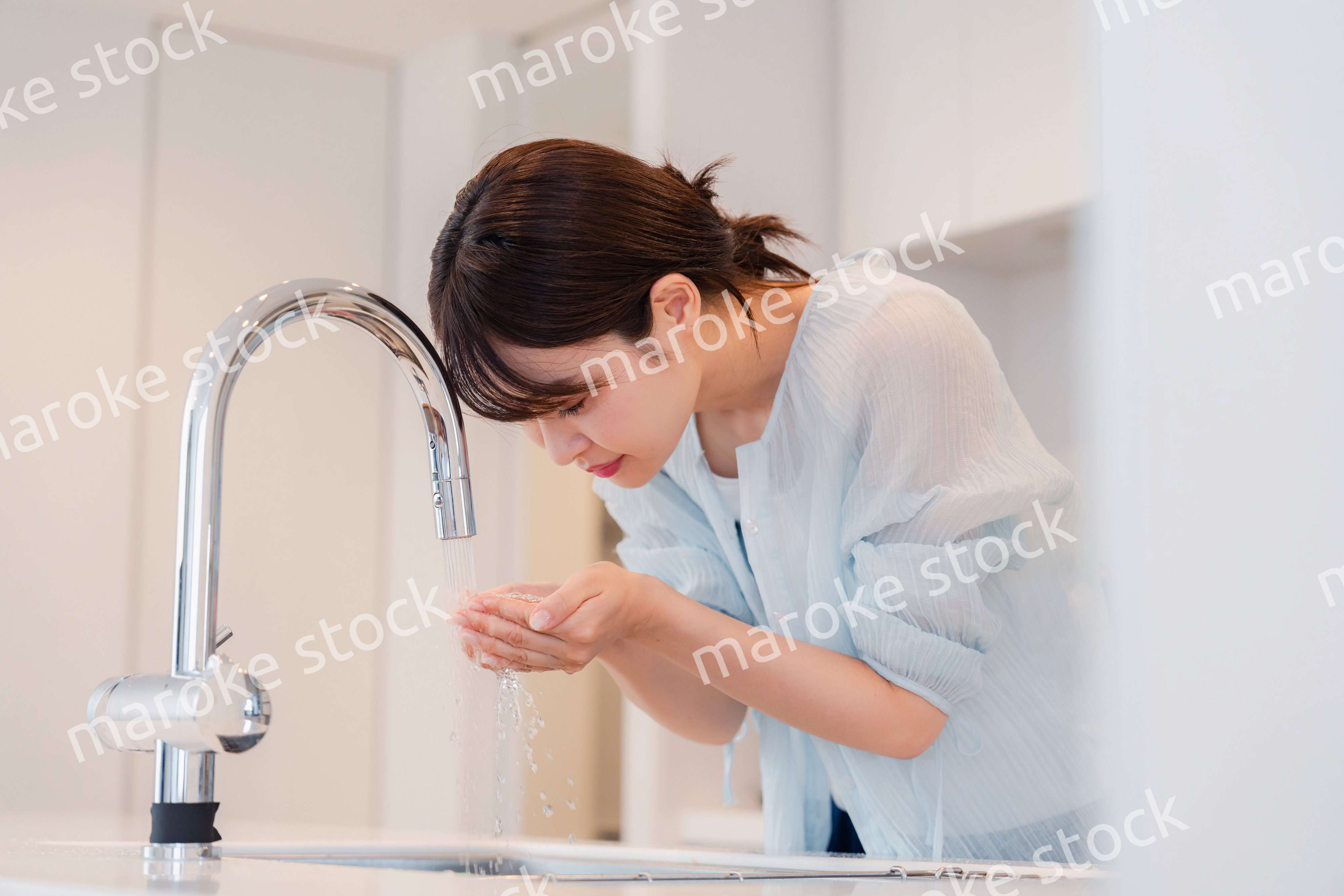 家で洗顔をする若い女性