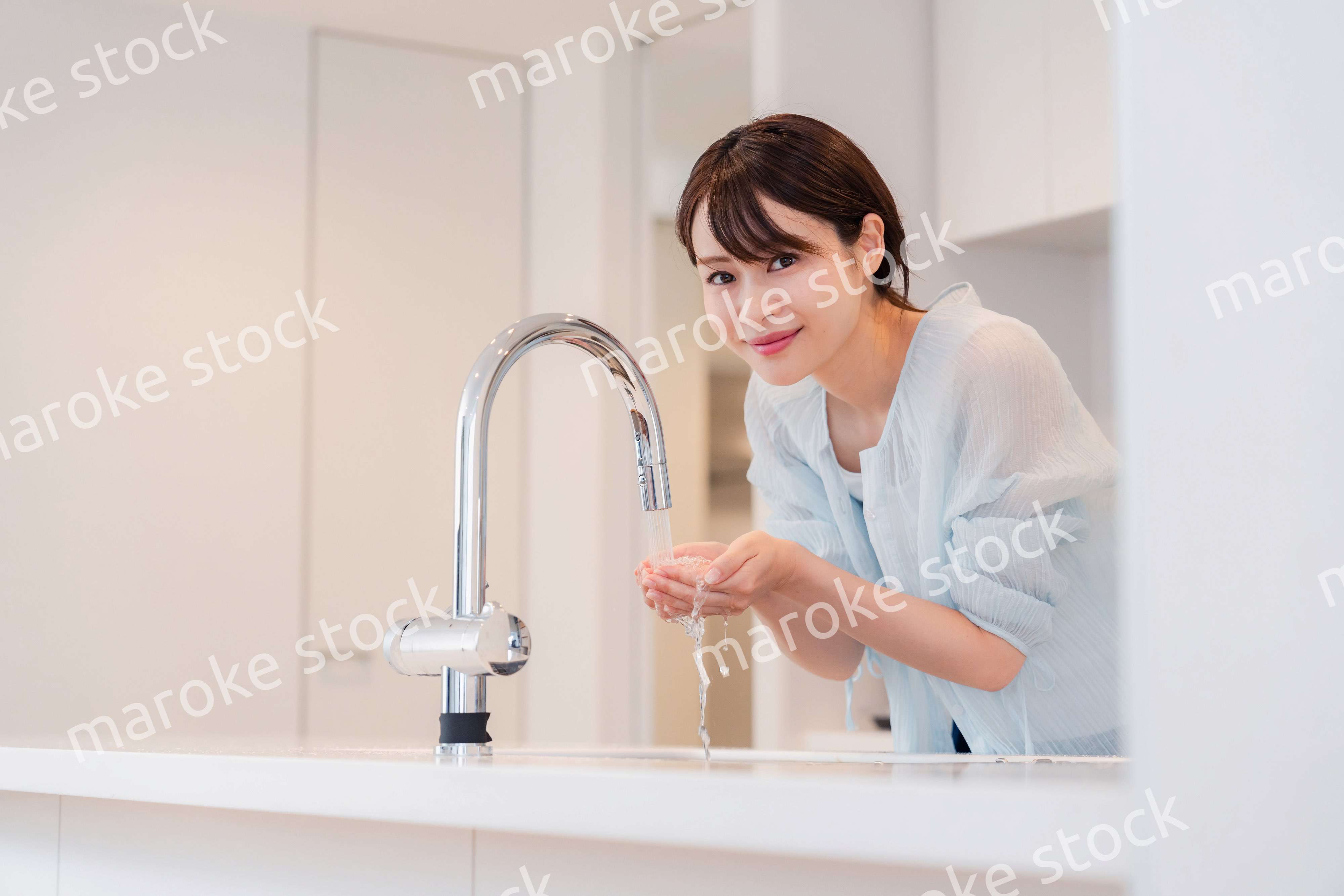 家で洗顔をする若い女性