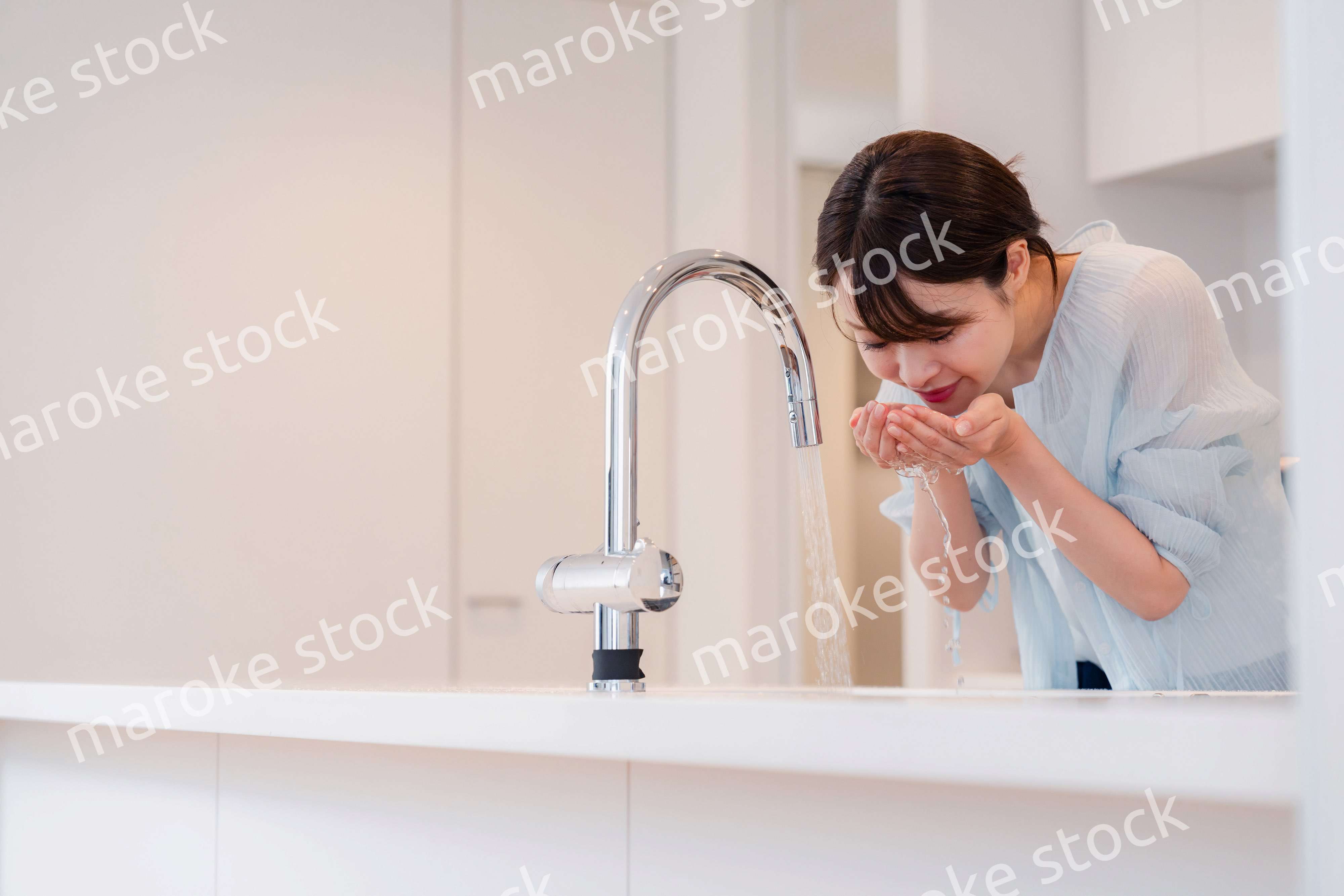 家で洗顔をする若い女性
