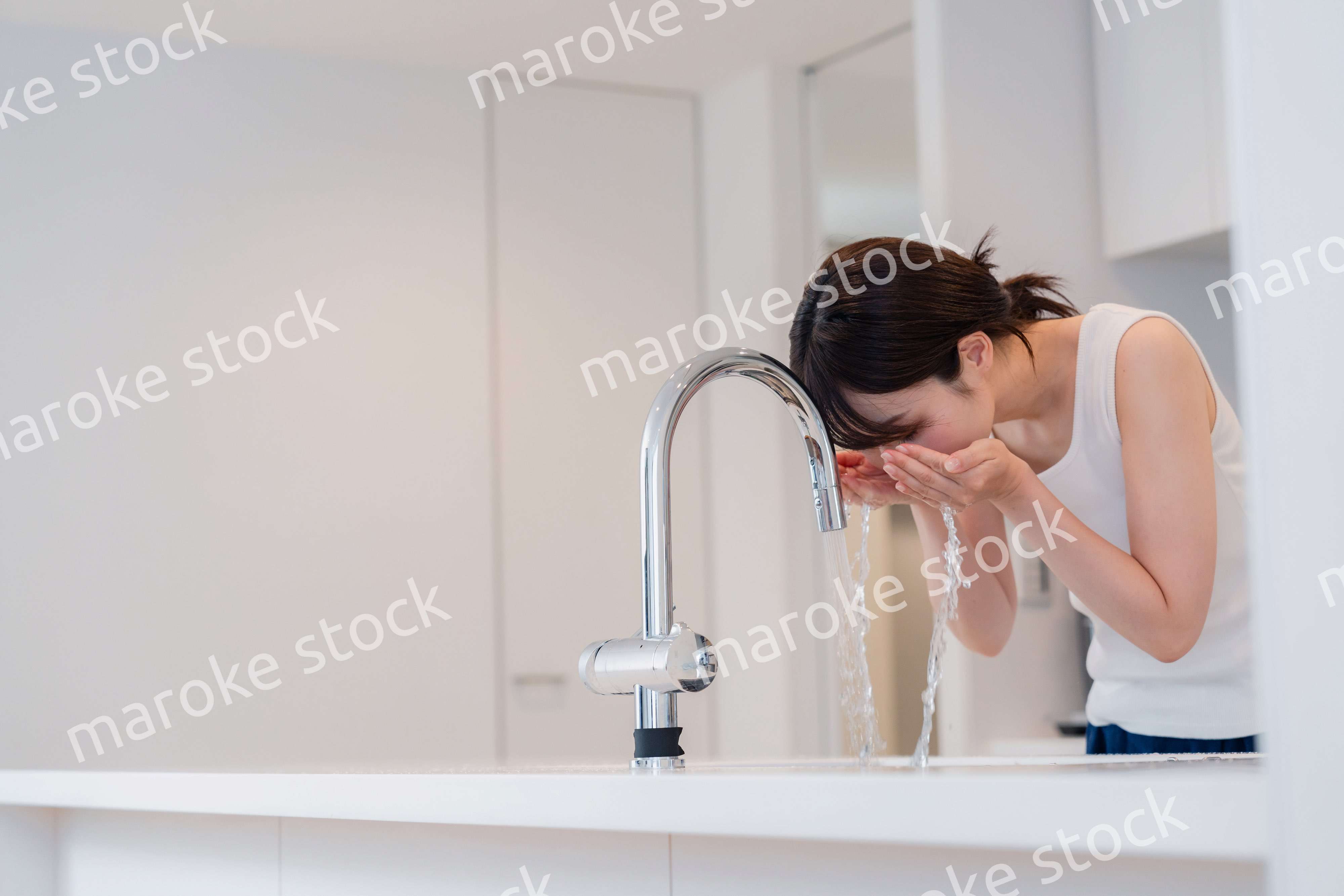 家で洗顔をする若い女性