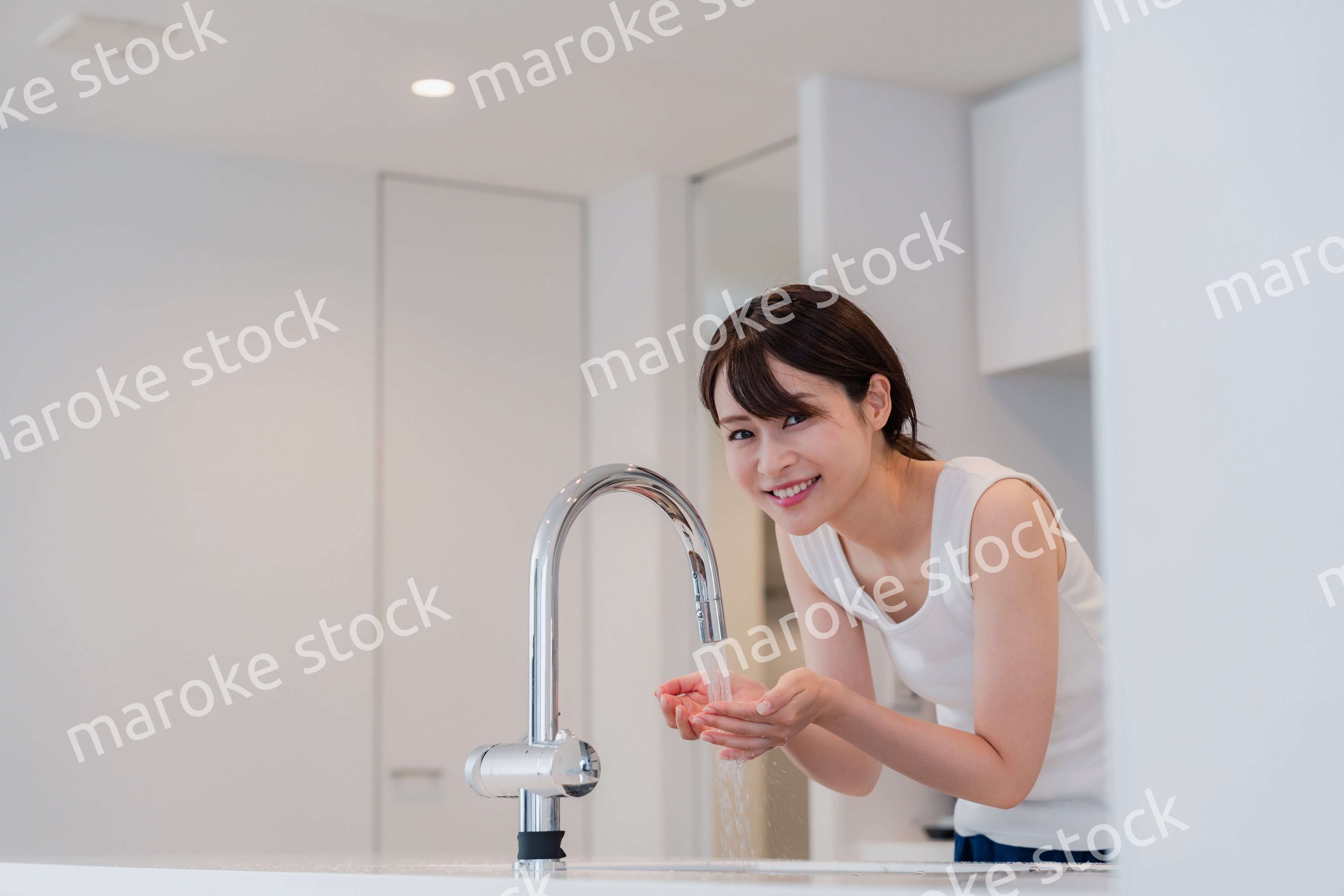 家で洗顔をする若い女性